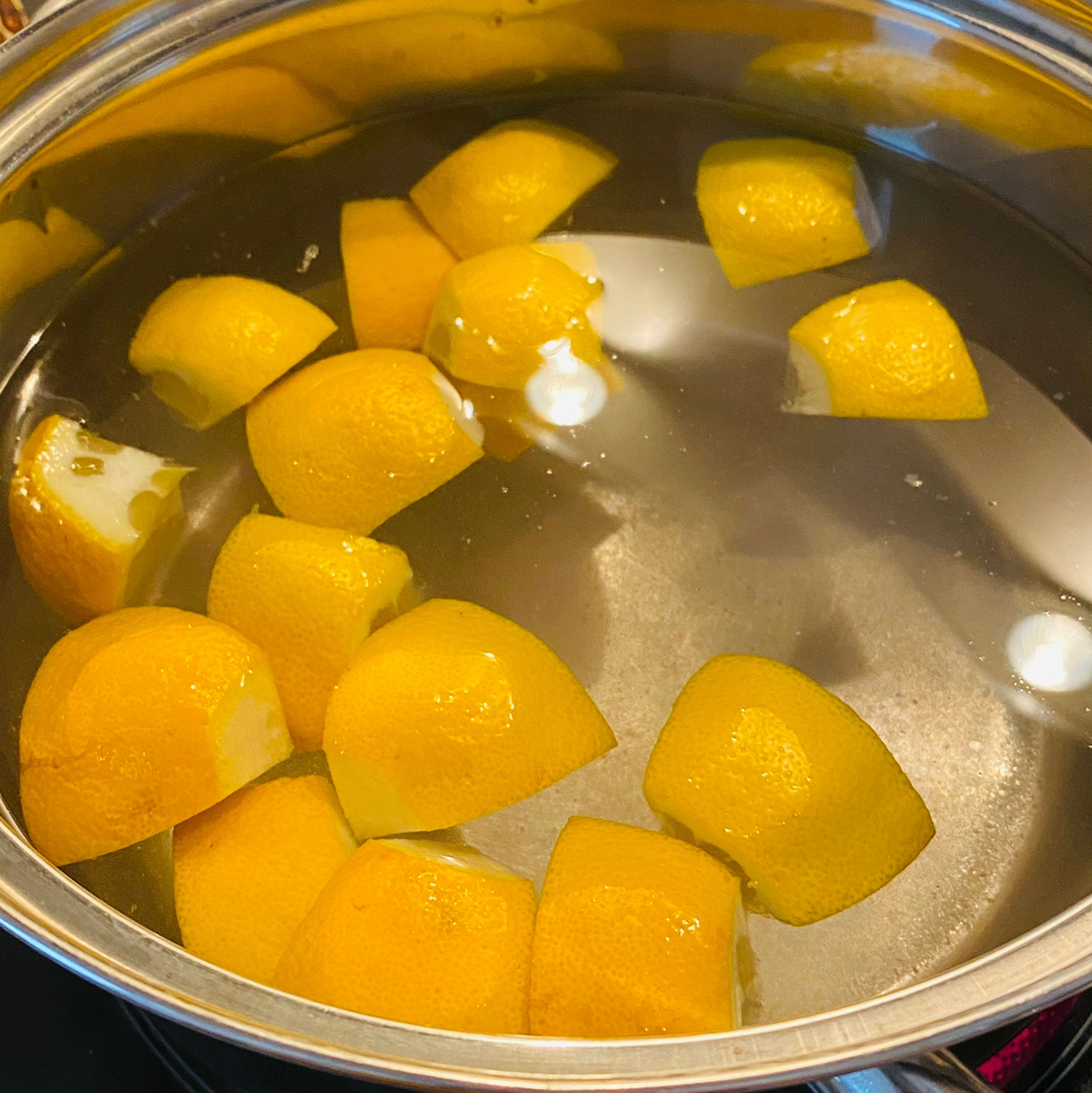 Salziges Wasser mit Zitronensaft und Zitronen aufkochen lassen.