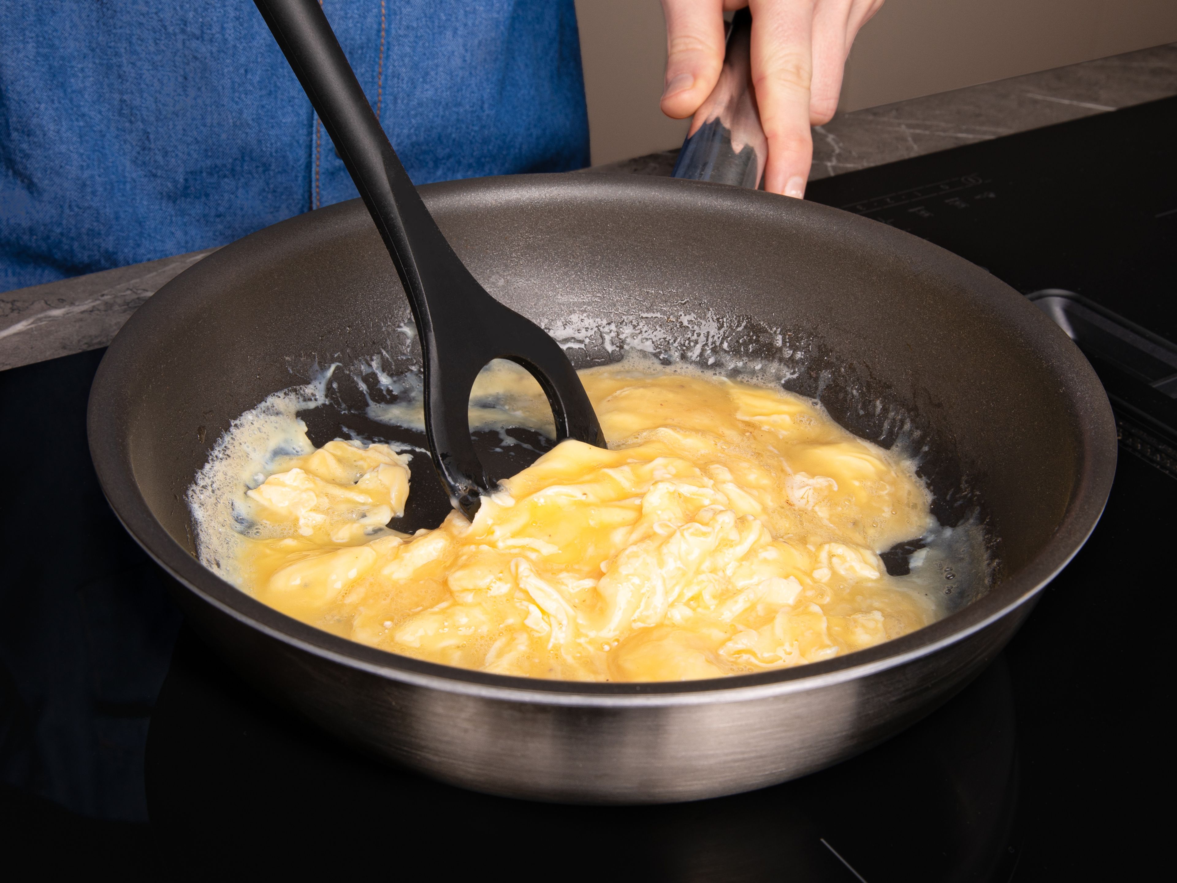 Etwas Pflanzenöl in einer Pfanne hoch erhitzen, Eier zugeben und ständig rühren, bis die Eier stocken. Eier auf einen Teller geben und zur Seite stellen.