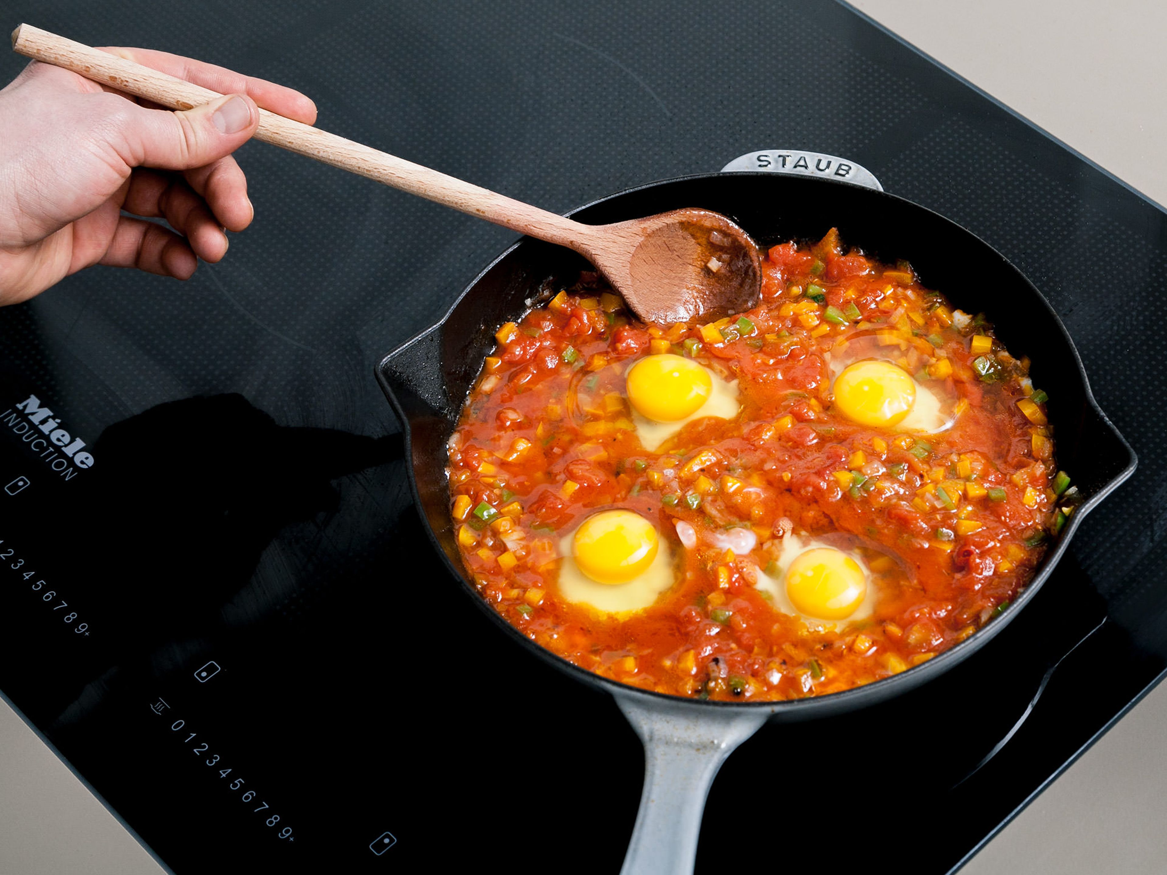 With a cooking spoon, create hollows in the pepper-tomato mixture and crack an egg in each hollow. Simmer for approx. 1 min., or until eggs are slightly set. Then, stir eggs in circular movements, distributing them around the pan. Simmer for approx. 5 more min., or until eggs have set. Crumble feta over and garnish with chopped parsley. Enjoy with fresh bread!
