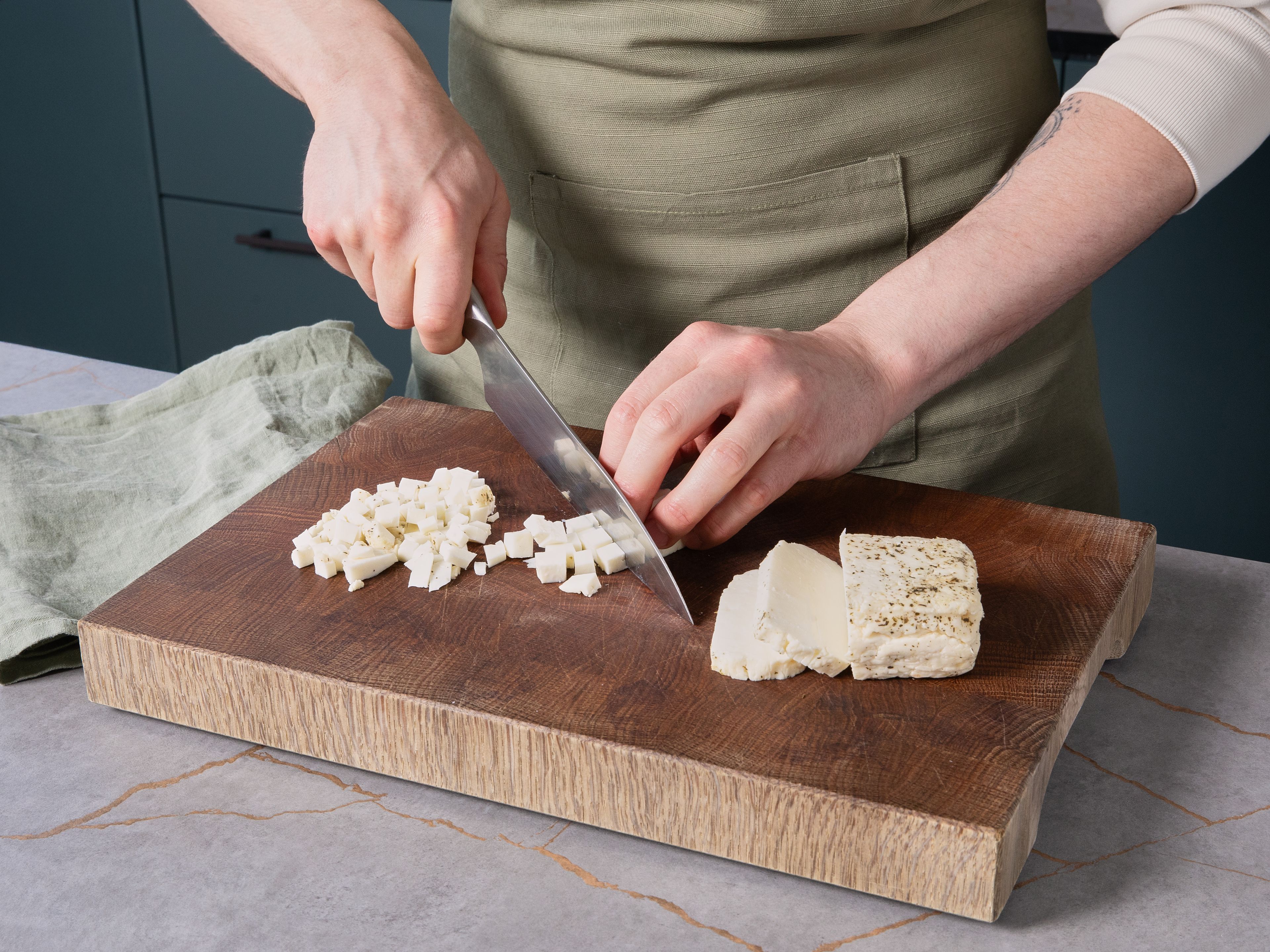 Den Backofen auf 160°C Ober-/Unterhitze vorheizen. Den Halloumi trockentupfen, in ca. 0,5 cm kleine Würfel schneiden und in einer Schüssel mit der Speisestärke vermengen. Ein Backblech mit Backpapier auslegen, den Halloumi darauf großflächig verteilen. Im vorgeheizten Ofen ca. 20–25 Min. goldbraun backen, bis alles schön knusprig ist. Währenddessen mit dem Rezept fortfahren.