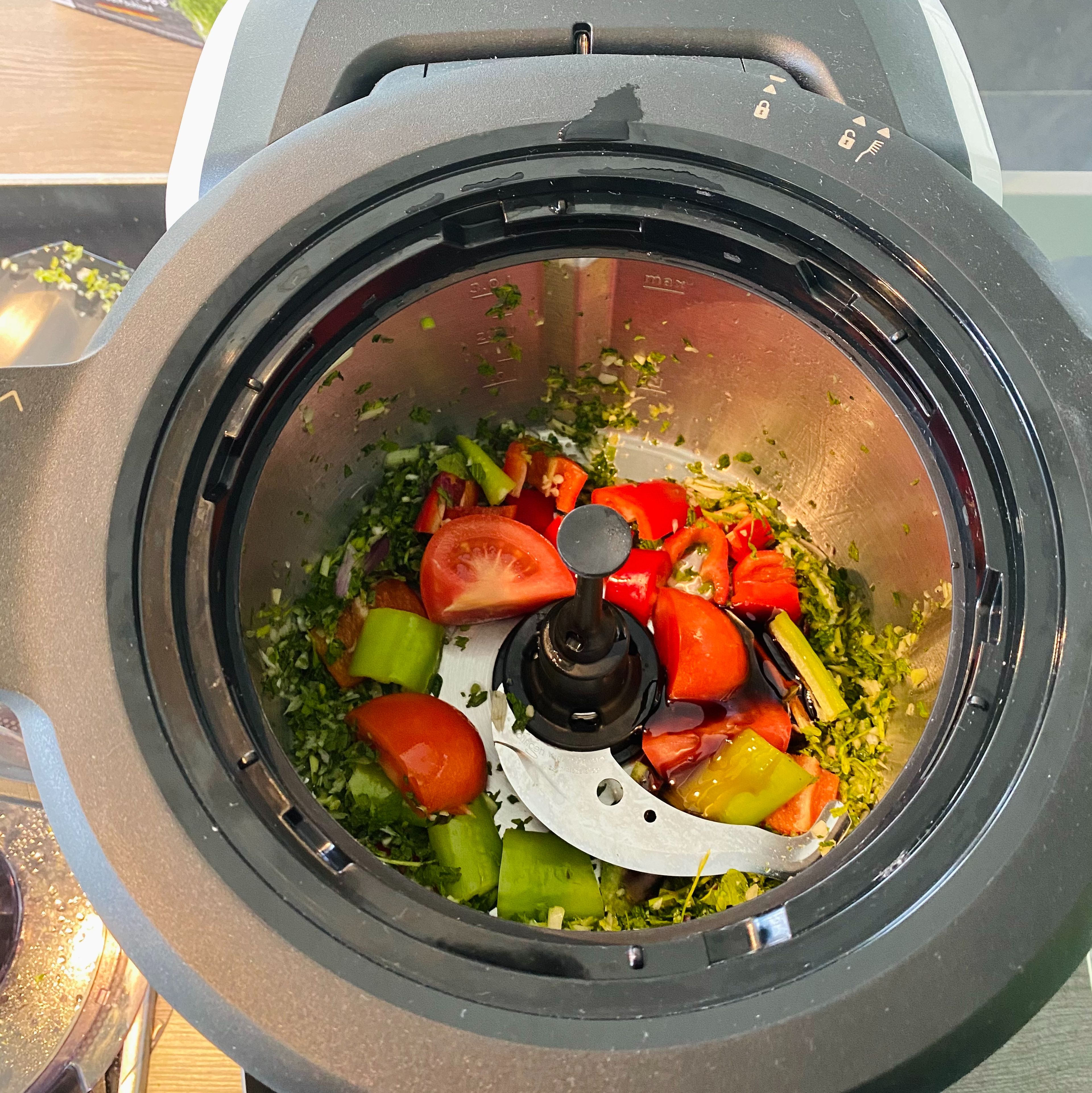 Die Paprika in ca 2 bis 3 cm große Stücke schneiden, die Tomaten vierteln und mit dem Zitronensaft und dem Granatapfelsirup in den Topf geben. Den Deckel mit dem Messbecher schließen und zerkleinern (Universalmesser I Stufe 9 I 15 Sek.).