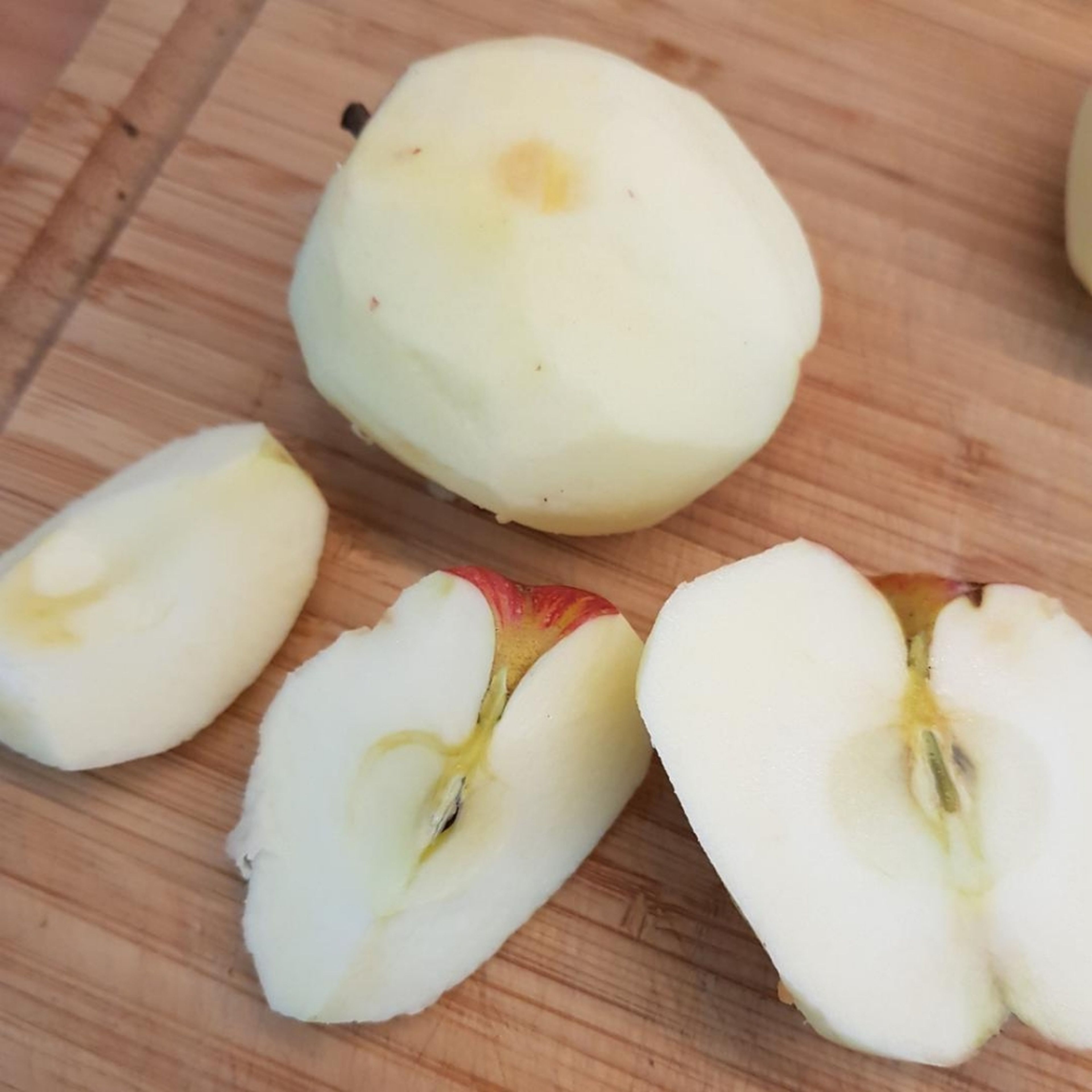 Äpfel schälen, halbieren, entkernen und in dicke Spalten schneiden