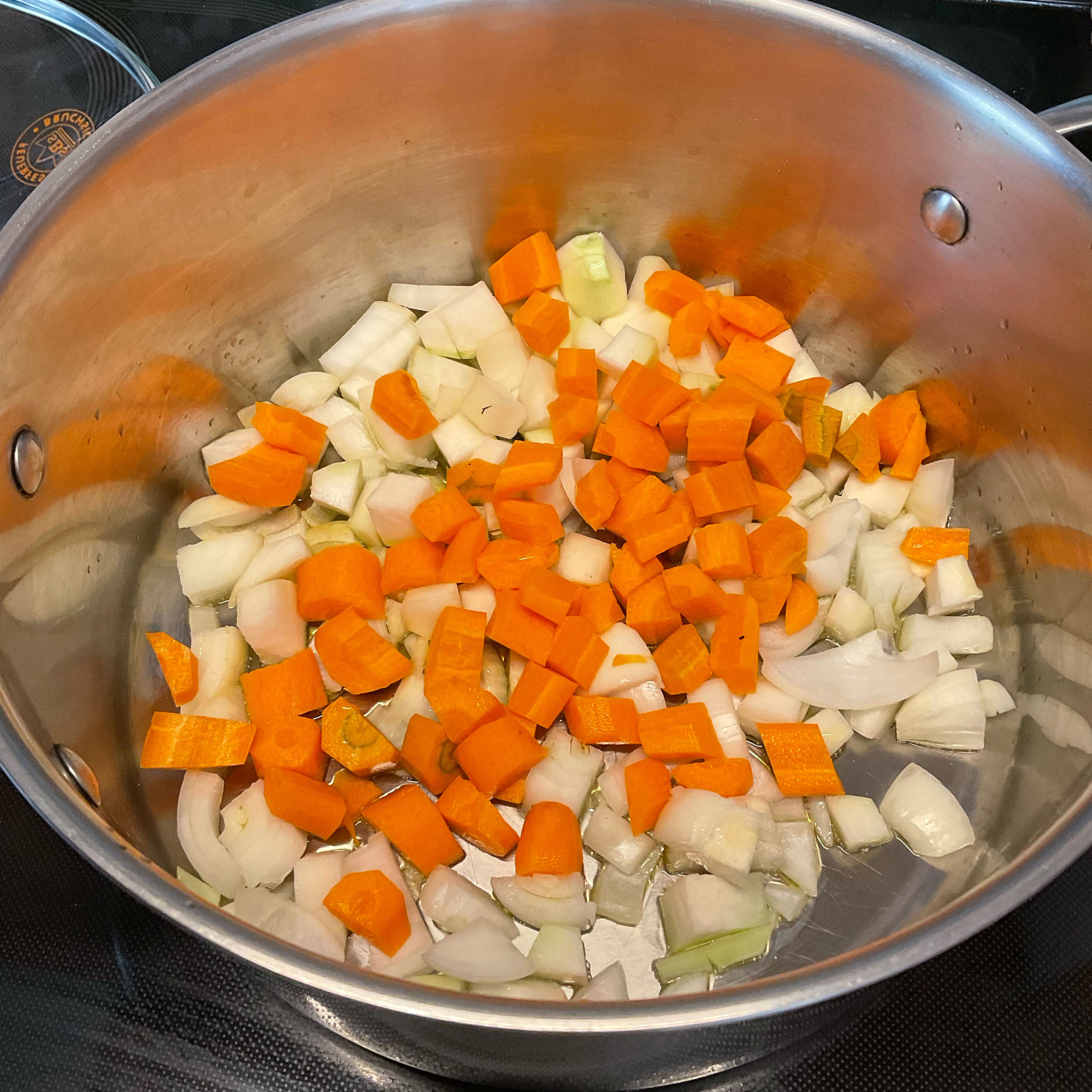 Zwiebeln, Karotten und Knollensellerie putzen, würfeln und in wenig Rapsöl scharf anbraten.