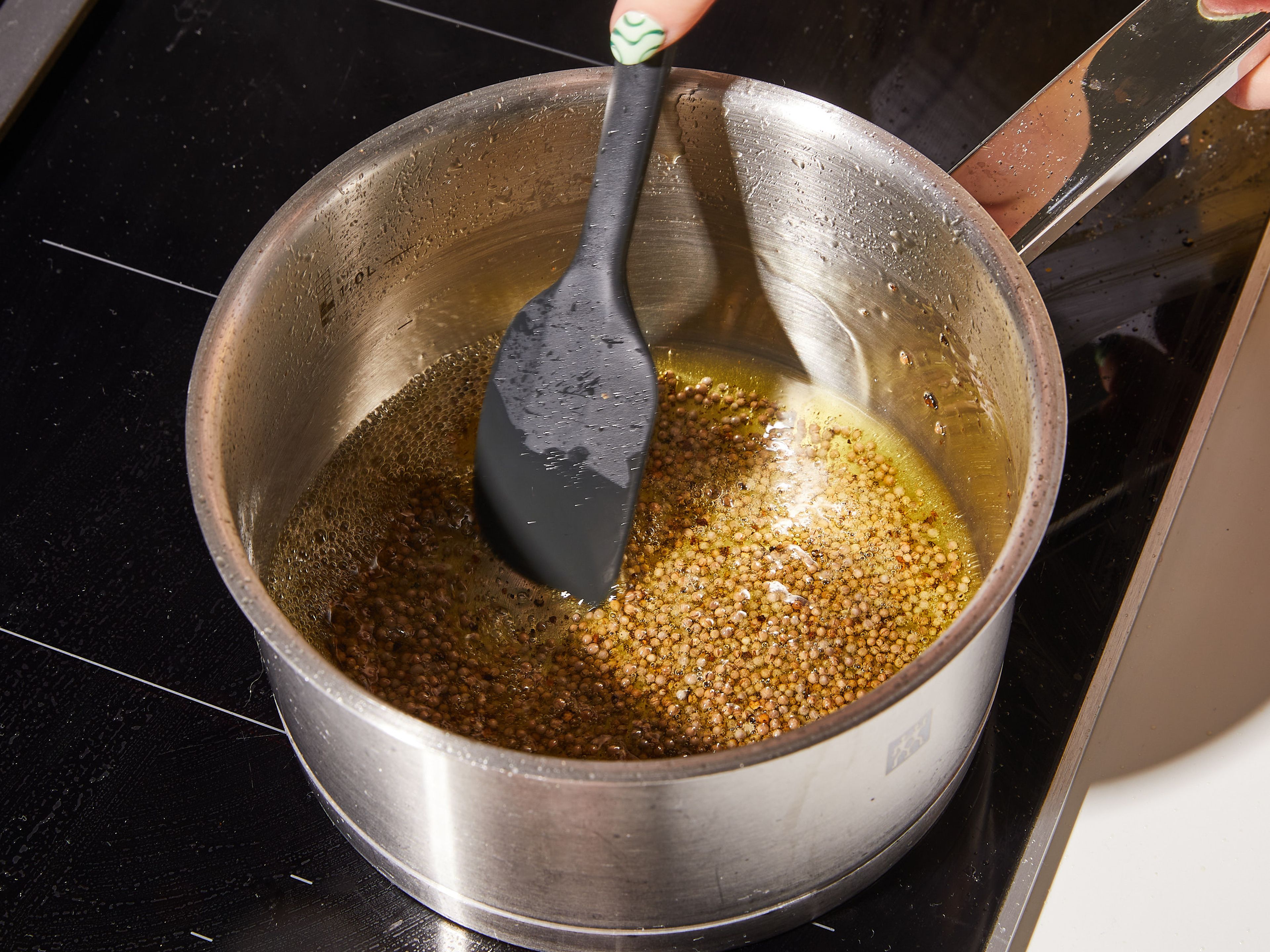 In a small saucepan on medium-high heat, heat mustard seeds with some black pepper and olive oil, until they start to sizzle, smell like popcorn, and turn a light brown. Then add the hot mixture directly to the orange zest in the bowl. Next, add mustard, honey and vinegar and season with salt. Use a whisk to mix everything into a creamy dressing.