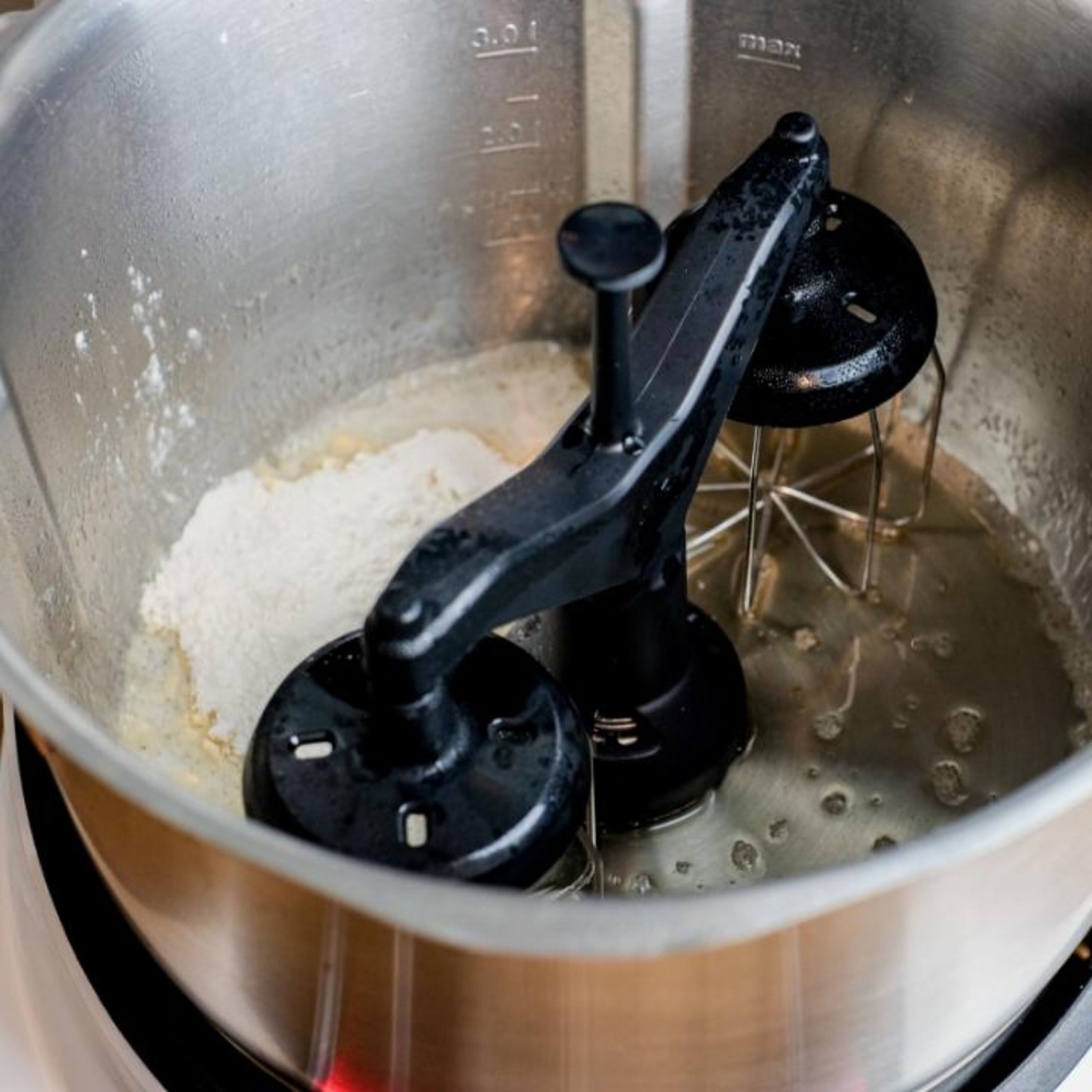 Topf grob säubern und trocknen. Zwillings-Rührbesen einsetzen. Die restliche Butter einwiegen und bei geschlossenem Deckel ohne Messbecher erhitzen Butter auf 60°C erhitzen.  (Zwillings-Rührbesen | Stufe | 130°C | 2 Min.).
Dann Mehl einwiegen und die Temperatur auf 95°C erhitzen (Zwillings-Rührbesen | Stufe 3 | 95°C | 3 Min.).