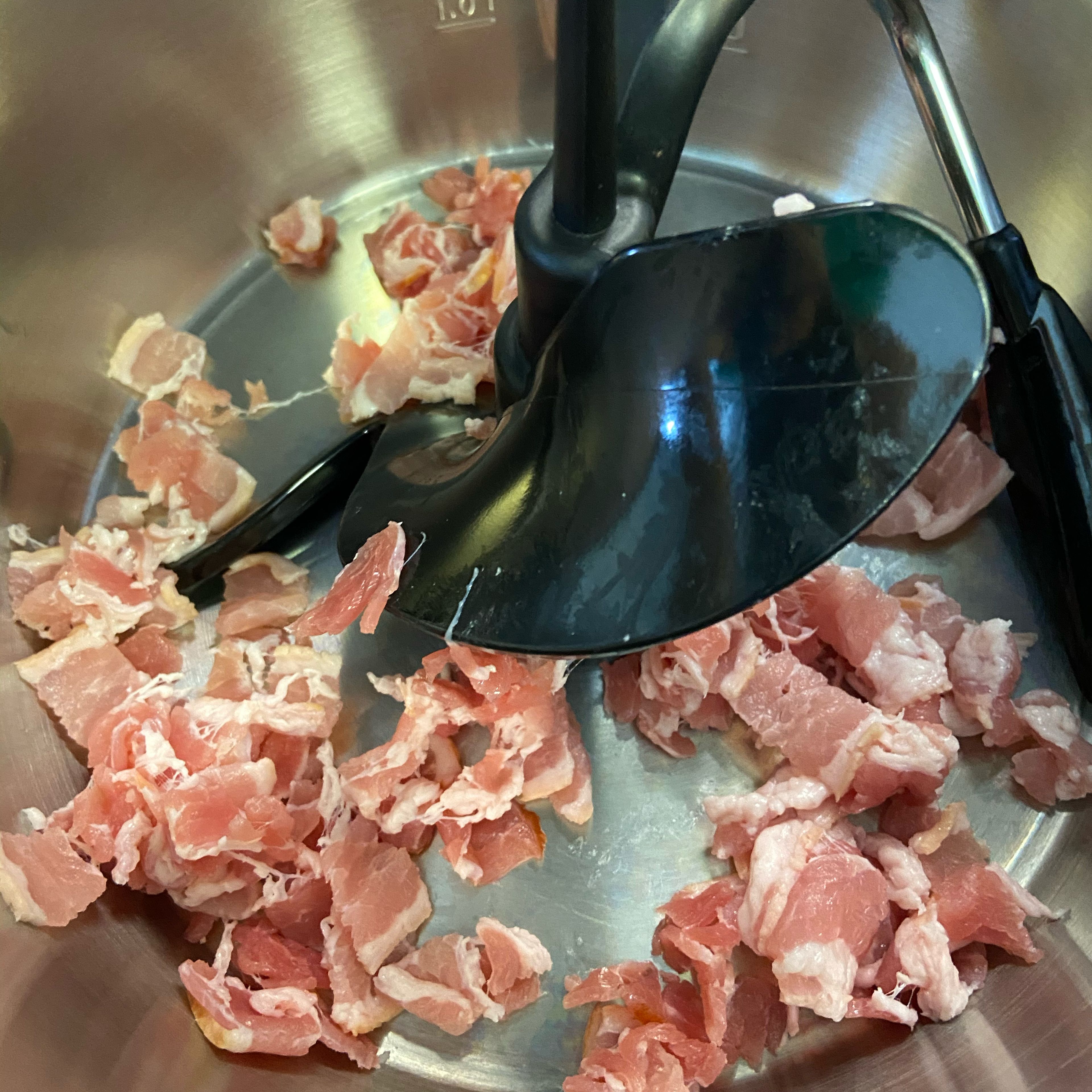 Die Bacon-Scheiben in dünne Streifen schneiden. Den Bacon ohne Öl in den Cookit geben und bei geschlossenem Deckel, ohne Messbecher, andünsten (3D-Rührer I Stufe 4 I 120°C I 4 Min.). Außerdem einen Topf mit reichlich Wasser zum Kochen bringen. Das Wasser salzen.