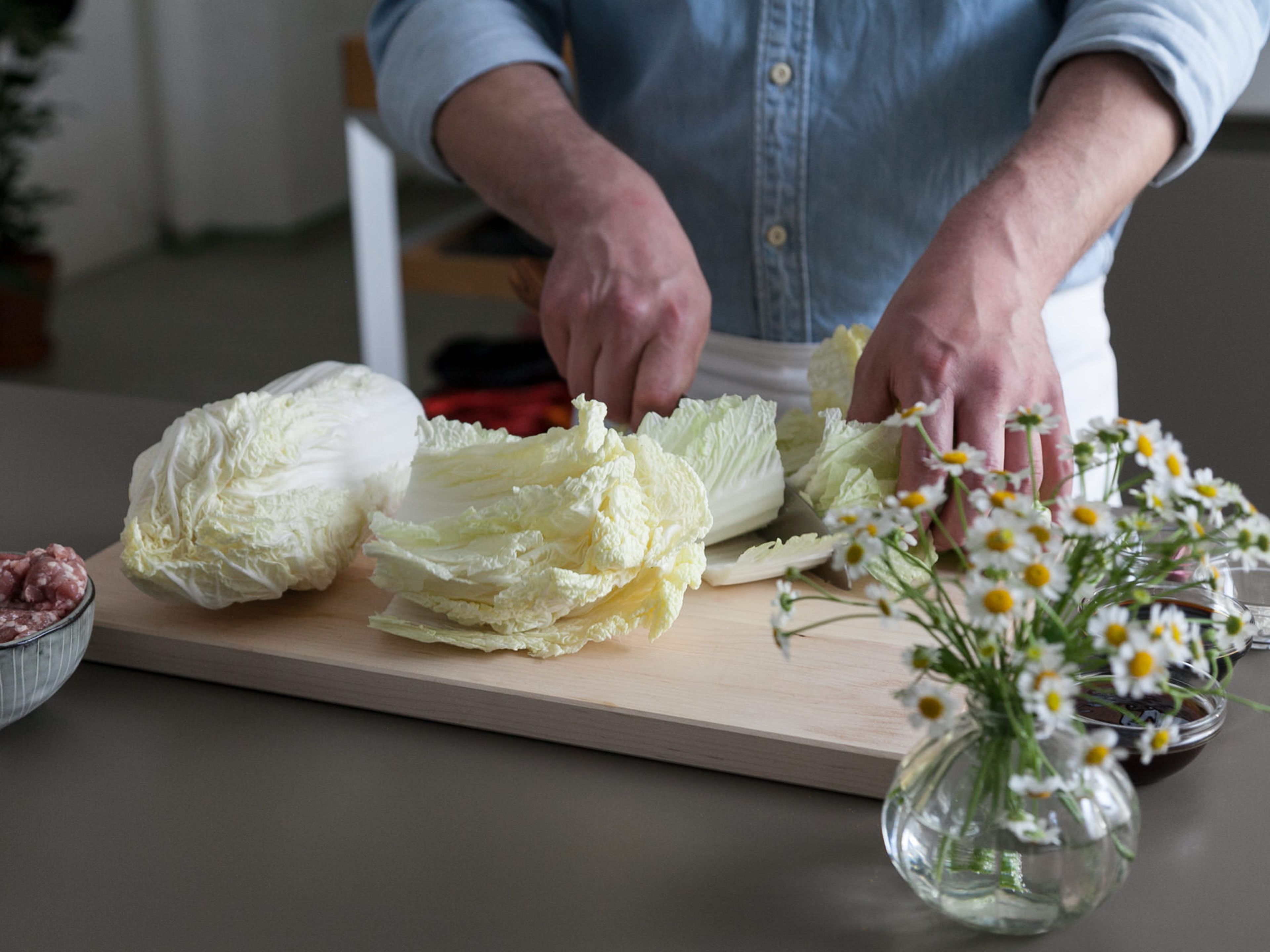 Peel and finely chop garlic, then set aside. Finely slice green onions and set aside, as well. Wash Chinese cabbage, cut off stem, and remove outer, dry leaves. According to serving size, remove some whole leaves for the cabbage rolls. Finely chop remaining inner leaves.