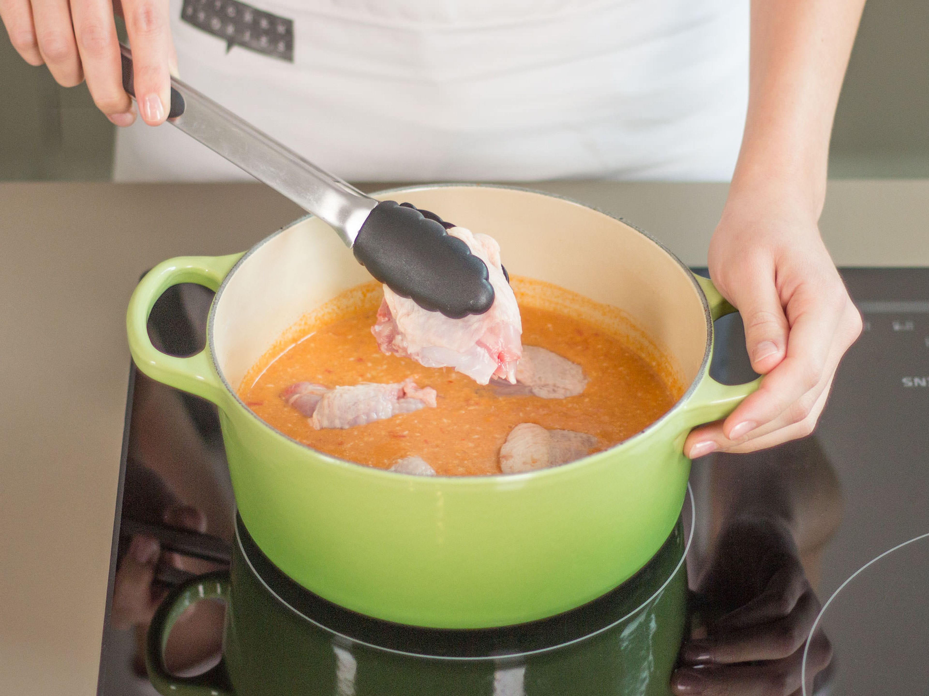 In a large saucepan, bring chicken stock to a boil and add chili pesto. Stir thoroughly until everything is fully combined. Now, add chicken thighs and simmer for approx. 3 – 5 min. Remove from heat.