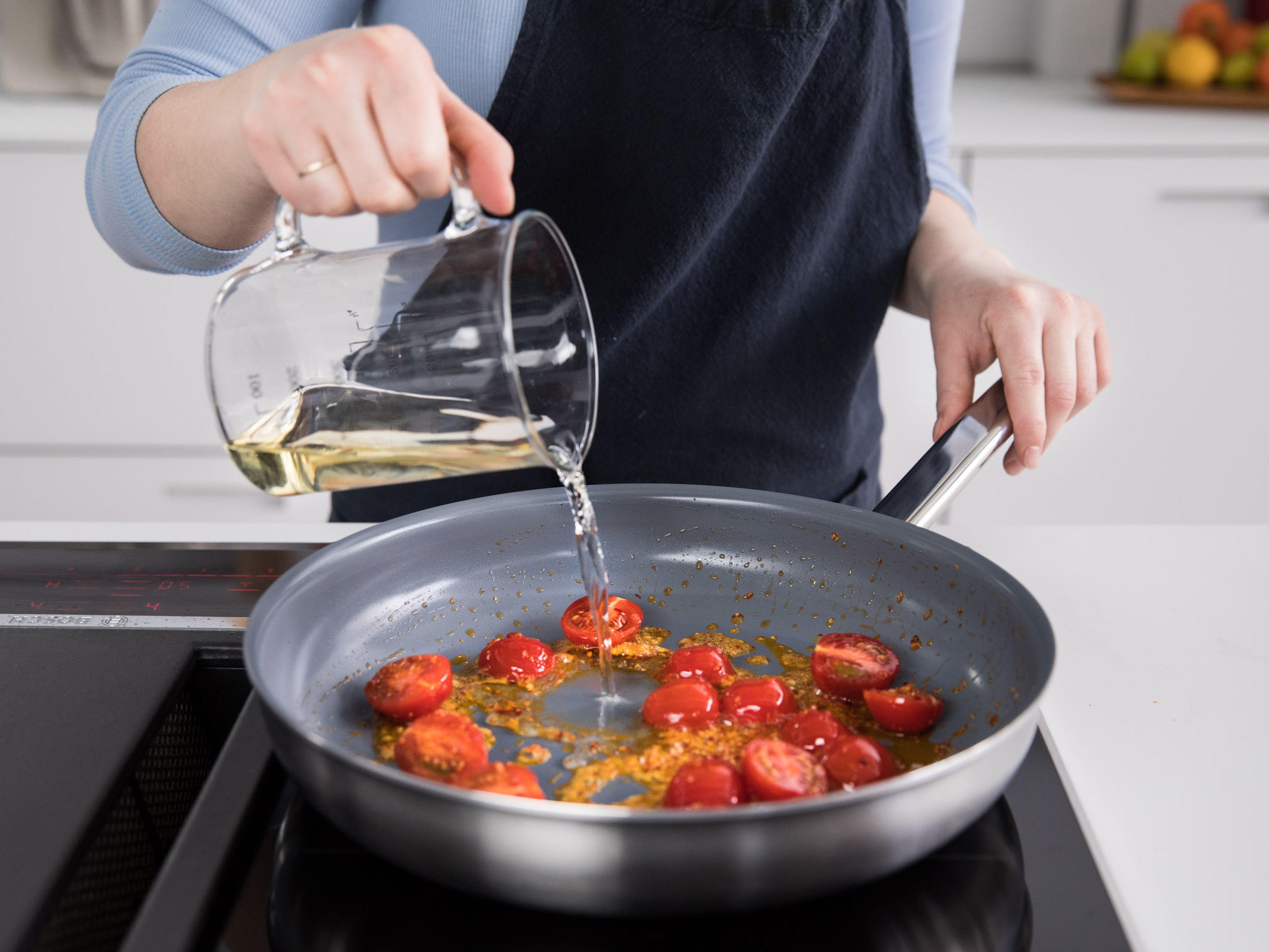 Olivenöl in einer Pfanne über mittlerer Hitze erwärmen. Knoblauch und Schalotte anschwitzen, bis sie glasig sind. Tomatenmark einrühren und die Kirschtomaten dazugeben. Ca. 1 - 2 Min. anbraten, oder bis das Tomatenmark dunkler wird und leicht anbrät. Mit Weißwein ablöschen und ca. 5 Min. köcheln lassen.