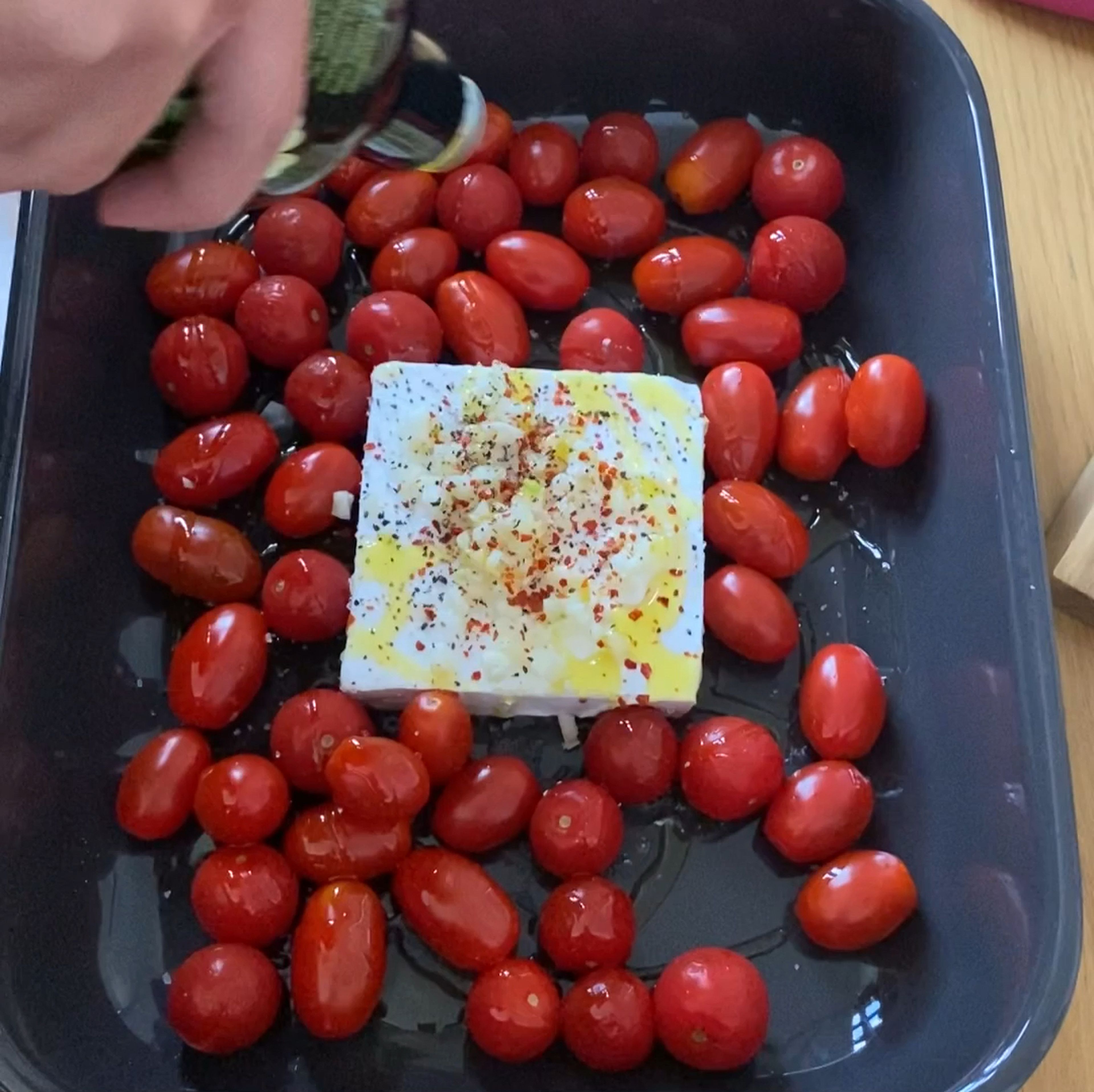 Den veganen Feta mit den Tomaten und Knoblauch in eine Ofen feste Form geben. Den Feta mit Salz, Chili und Pfeffer bestreuen und ordentlich Oliven Öl drüber träufeln. Für 15 min bei 200 grad C ( Ober unter Hitze) backen. Falls er noch nicht weich nach 15 min ist, bitte noch ein paar Minuten drin lassen.