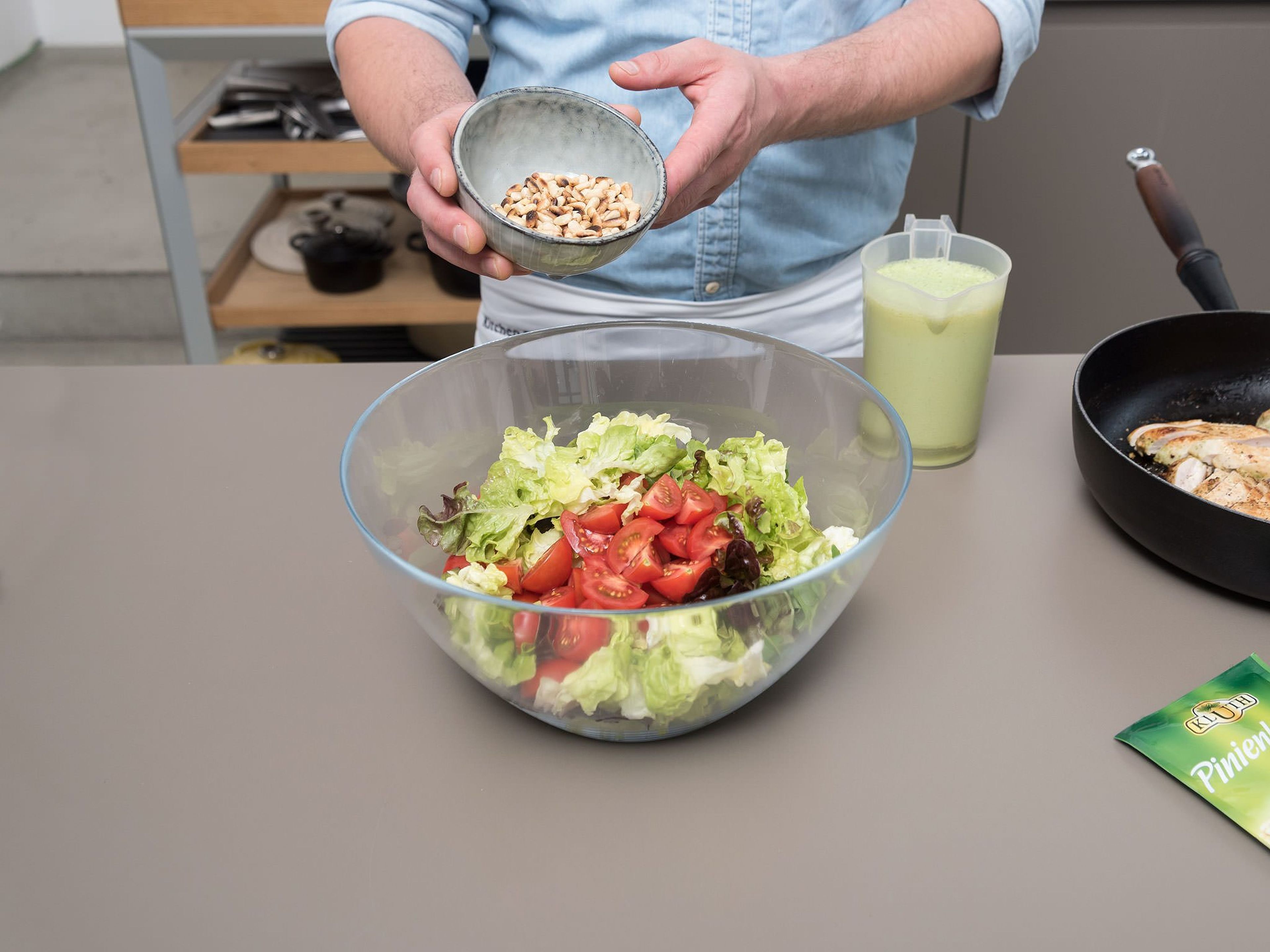 In the meantime, toast pine nuts in small frying pan over medium heat for approx. 3 min., or until golden brown. Add to salad. Pour some of the remaining dressing on top and toss to coat. Plate salad and serve with chicken breast on top. Enjoy!