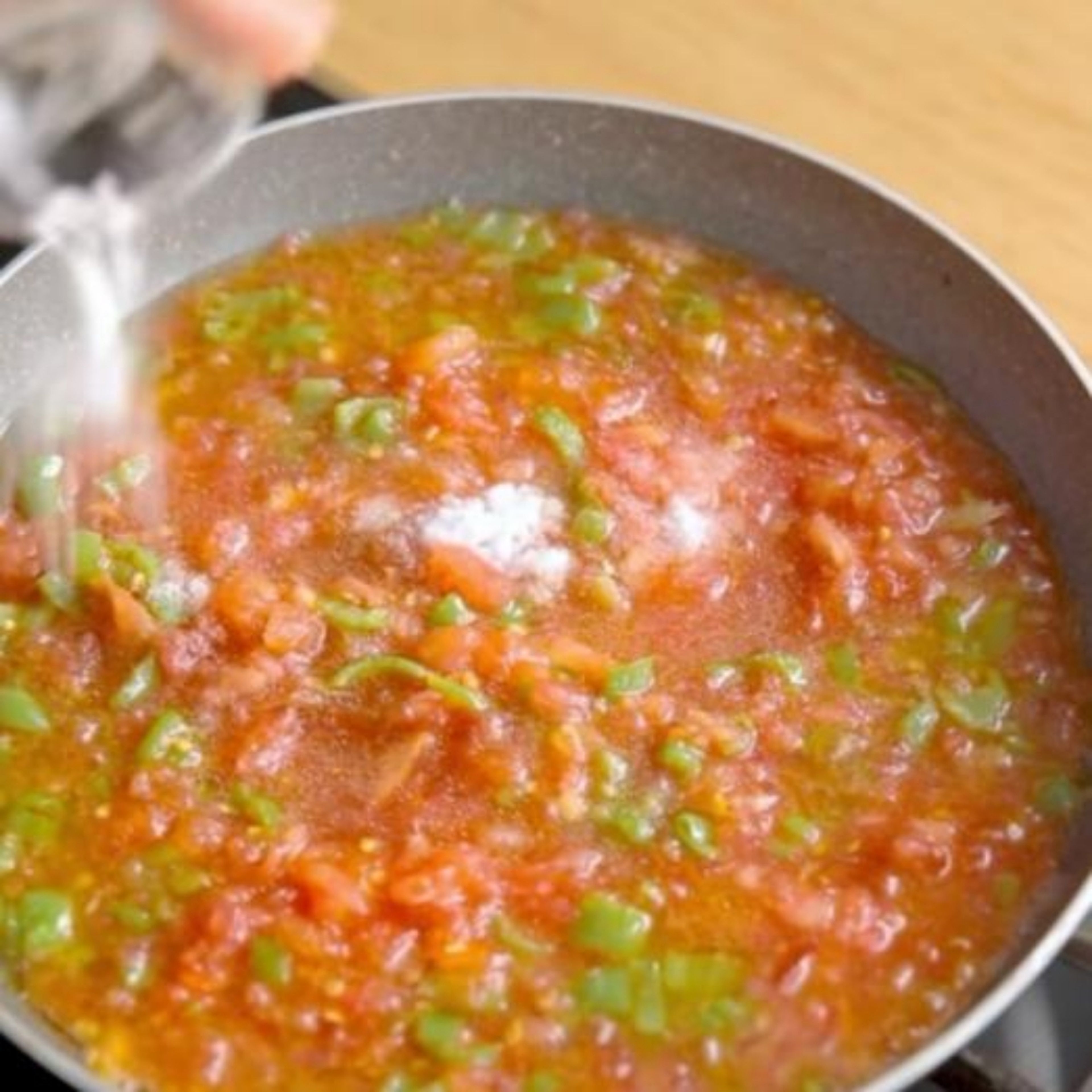 Die Tomaten Schälen und hacken. Gehackte Tomaten, Salz, Pfeffer und Paprikapulver in die Pfanne geben und kurz mischen. Anschließend ca. 10 min köcheln lassen bis die Tomaten weich geworden sind.