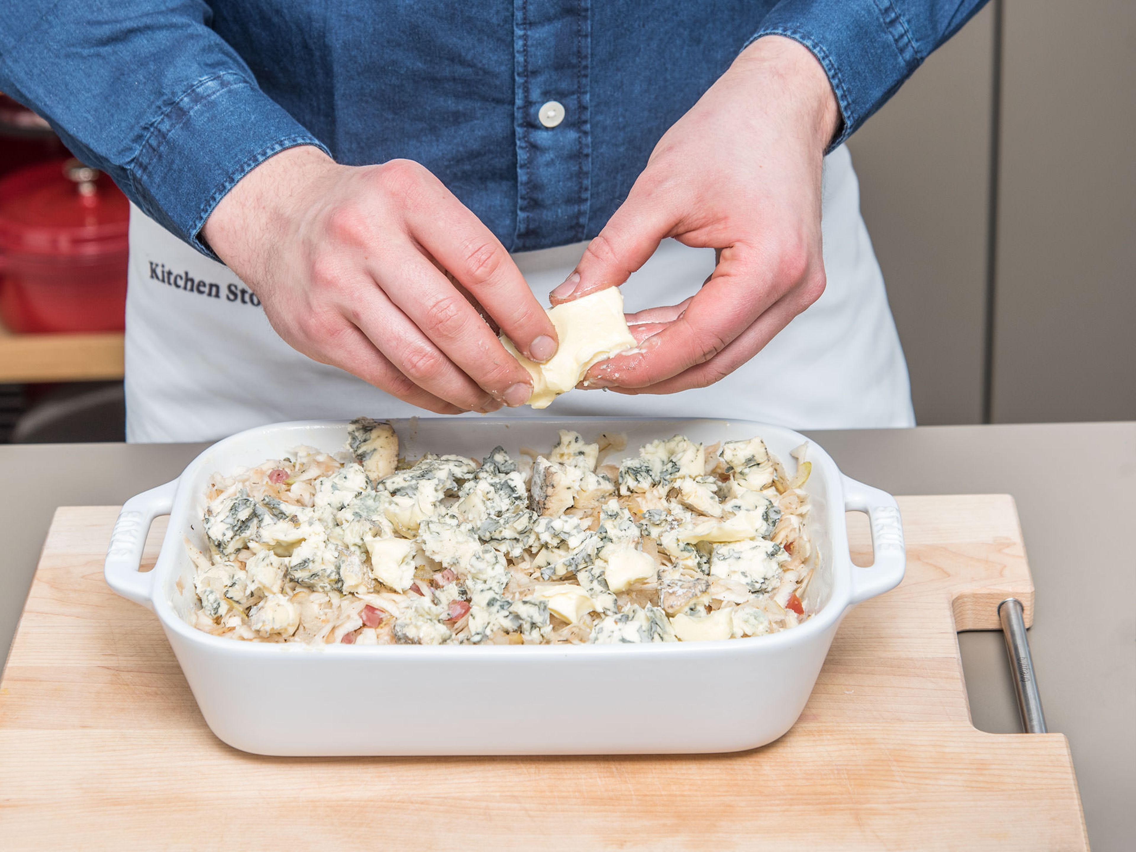 Add the mixture of celery root, pears, and bacon to the baking dish. Pour vegetable stock evenly over it. Crumble blue cheese and distribute crumbled blue cheese, butter, and ground almonds over the celery root-pear mixture.