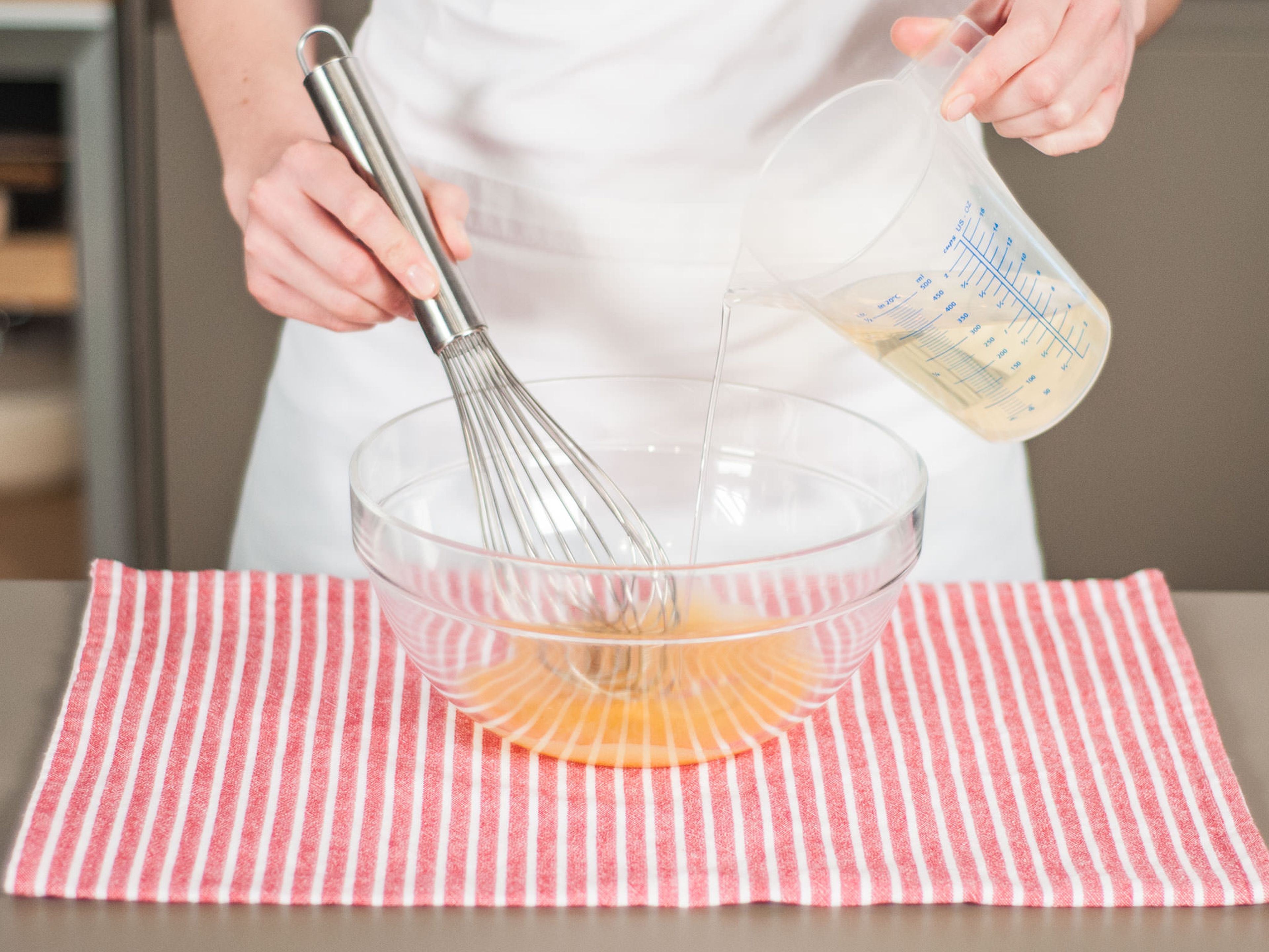 In a steady stream, add vegetable oil to egg yolks while stirring constantly. Whisk until fully incorporated. Then, season to taste with salt, pepper, and lemon juice.