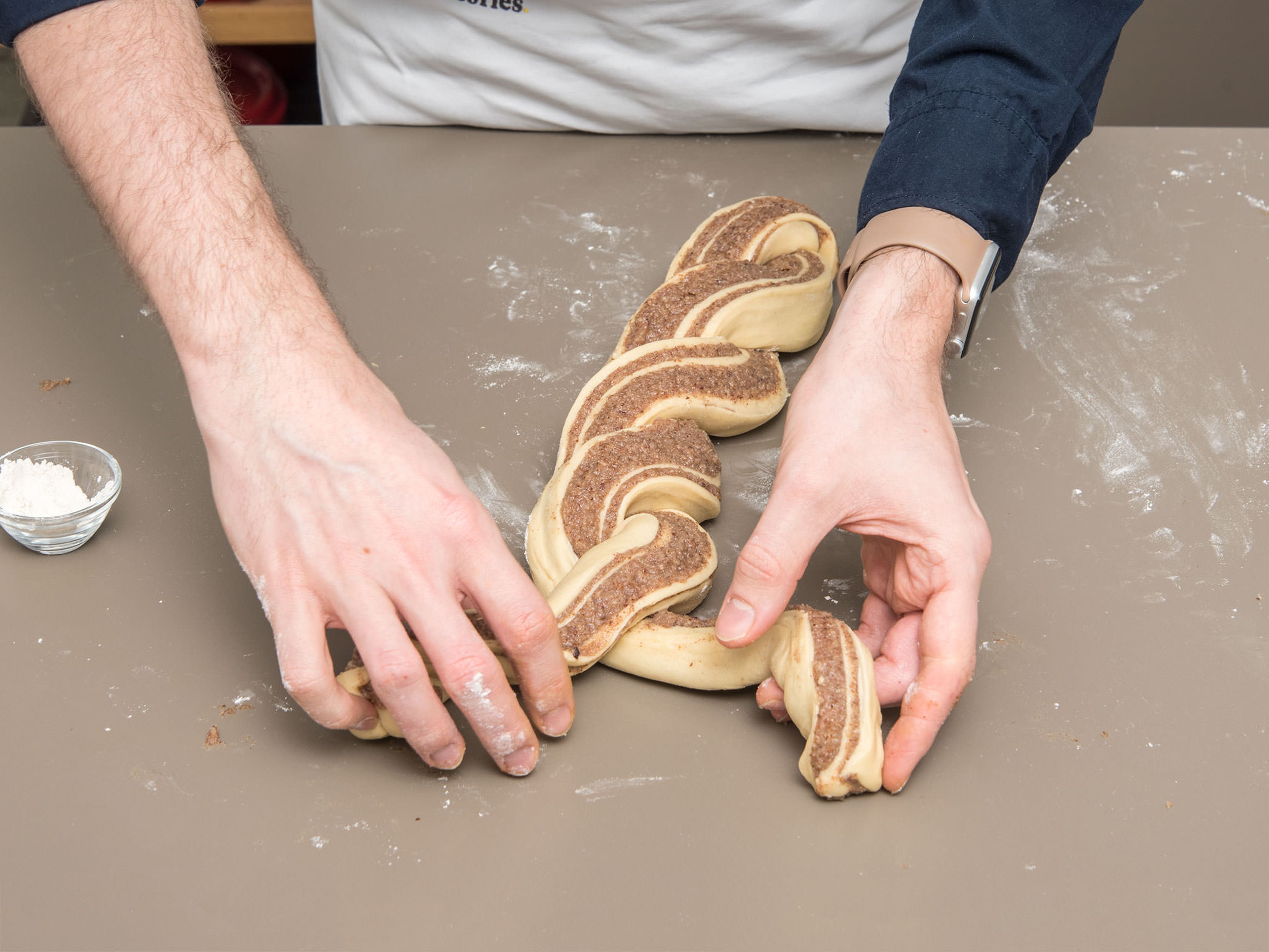 Roll up the dough along the width. Slice the dough along the length in half. Braid the two long logs carefully.