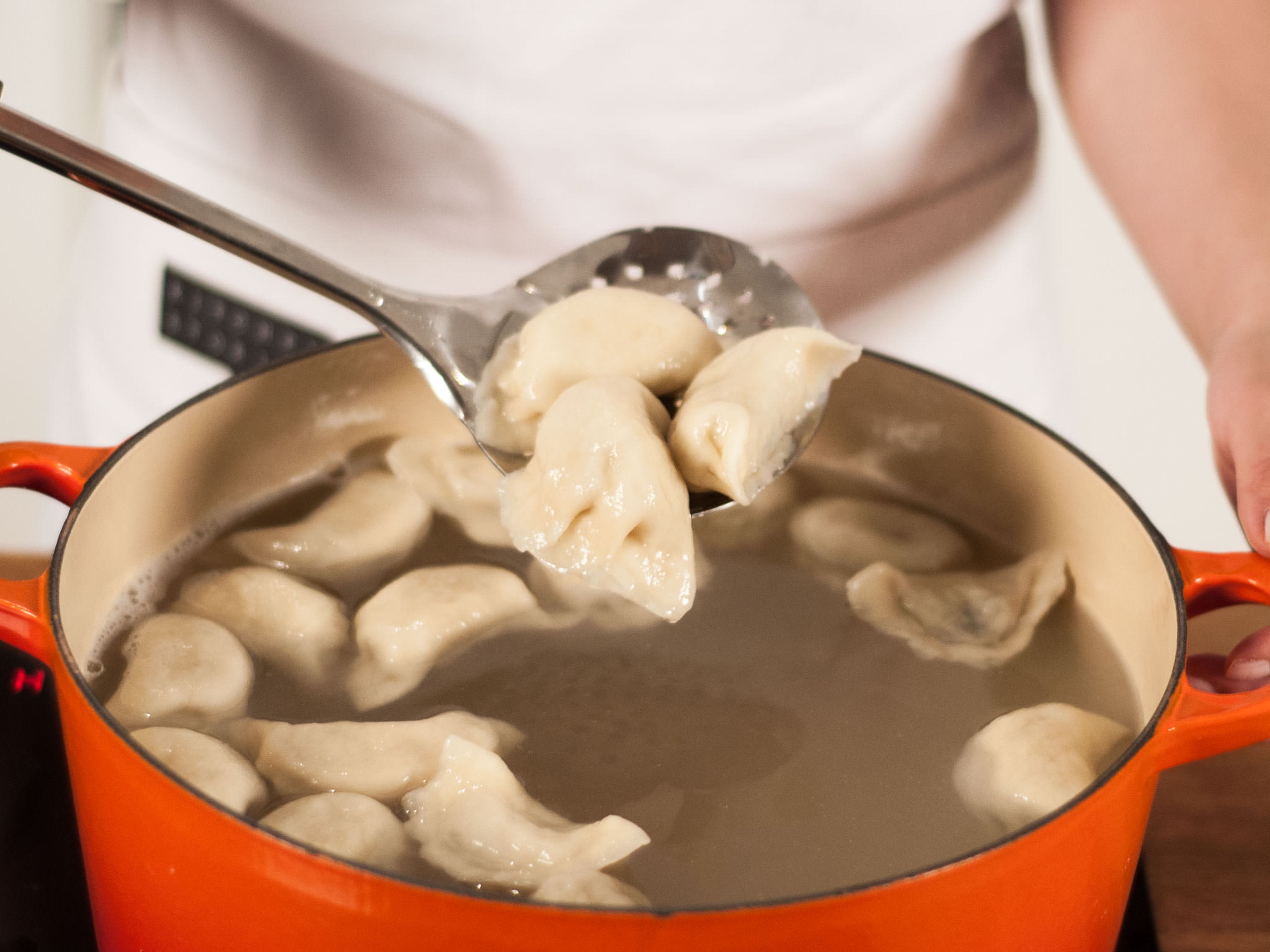When the fourth cup of cold water is added, immediately turn off the heat and remove dumplings from the pan using a skimmer. Place on a plate and allow to drain. Cook remaining dumplings.