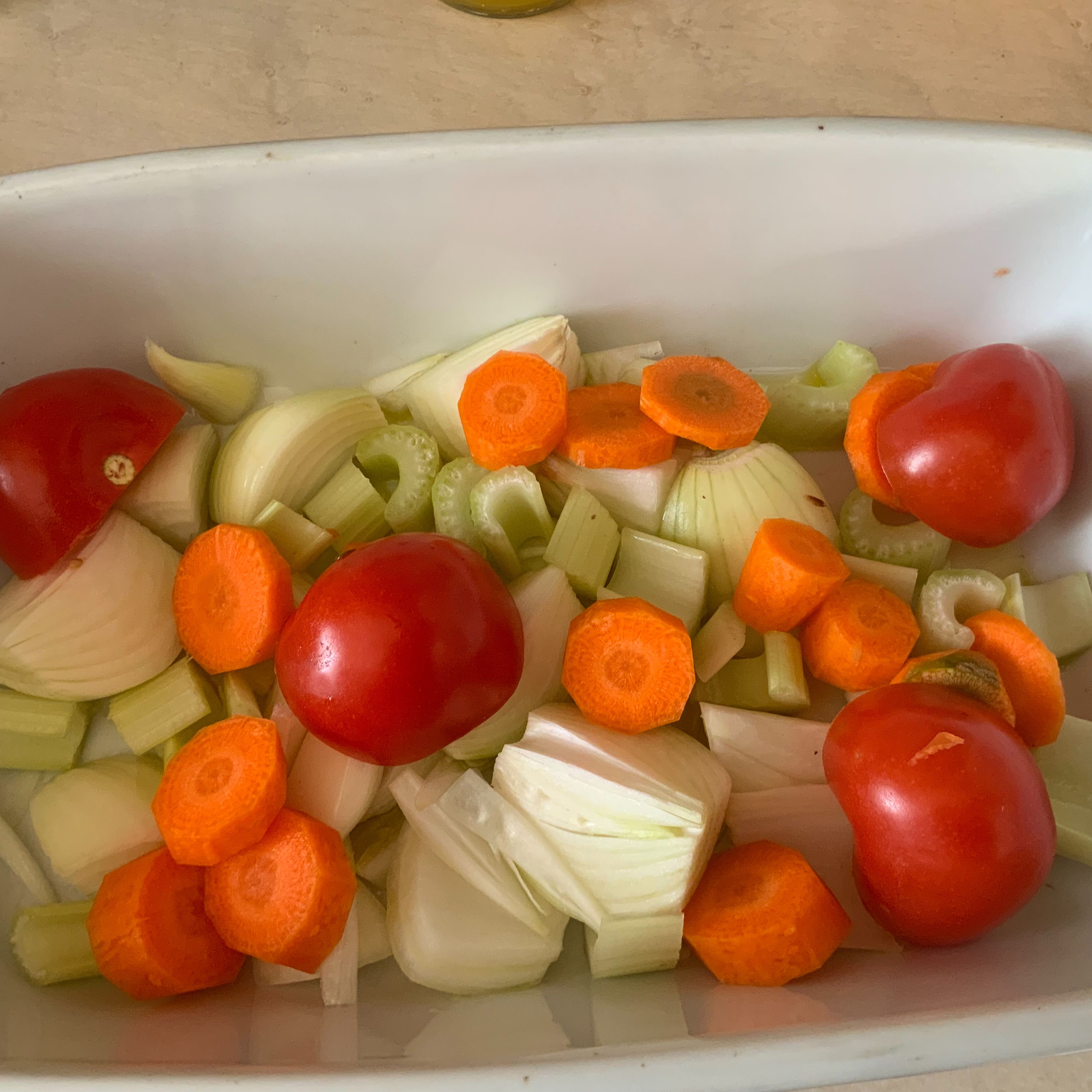 In den Bräter wenig Rapsöl hinzufügen und mit 2 Zwiebeln, dem Staudensellerie, der Karotte und den halbierten Tomaten ein Bett zubereiten. Die Keule drauf legen und bei 200°C Umluft 45 Minuten in das Backrohr geben.