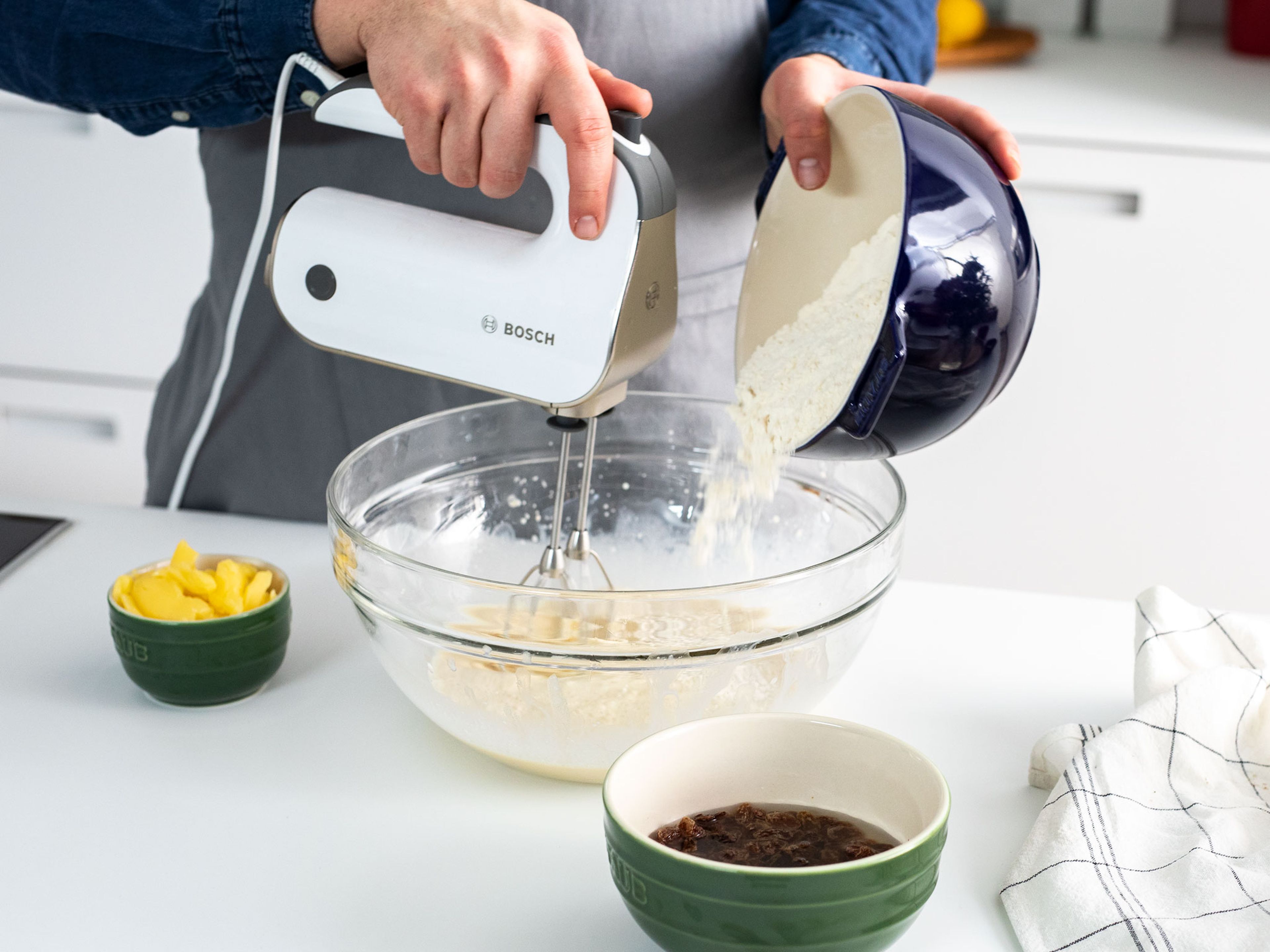 Soak raisins in cold water. Whisk together fresh yeast with milk and sugar. Add the flour, salt, and eggs. Using a hand mixer, mix all ingredients together until a dough forms. Allow dough to rise in a warm place for approx. 20 min.