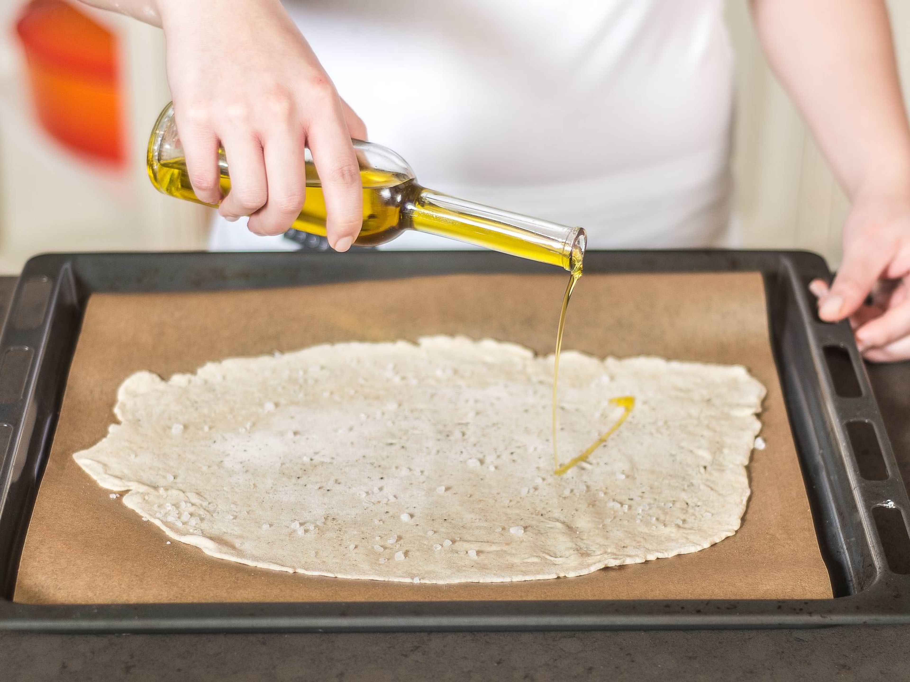 Transfer the flattened dough to a lined baking tray and sprinkle with red pepper and salt to taste. Drizzle with approx. 2 - 3 tbsp olive oil.