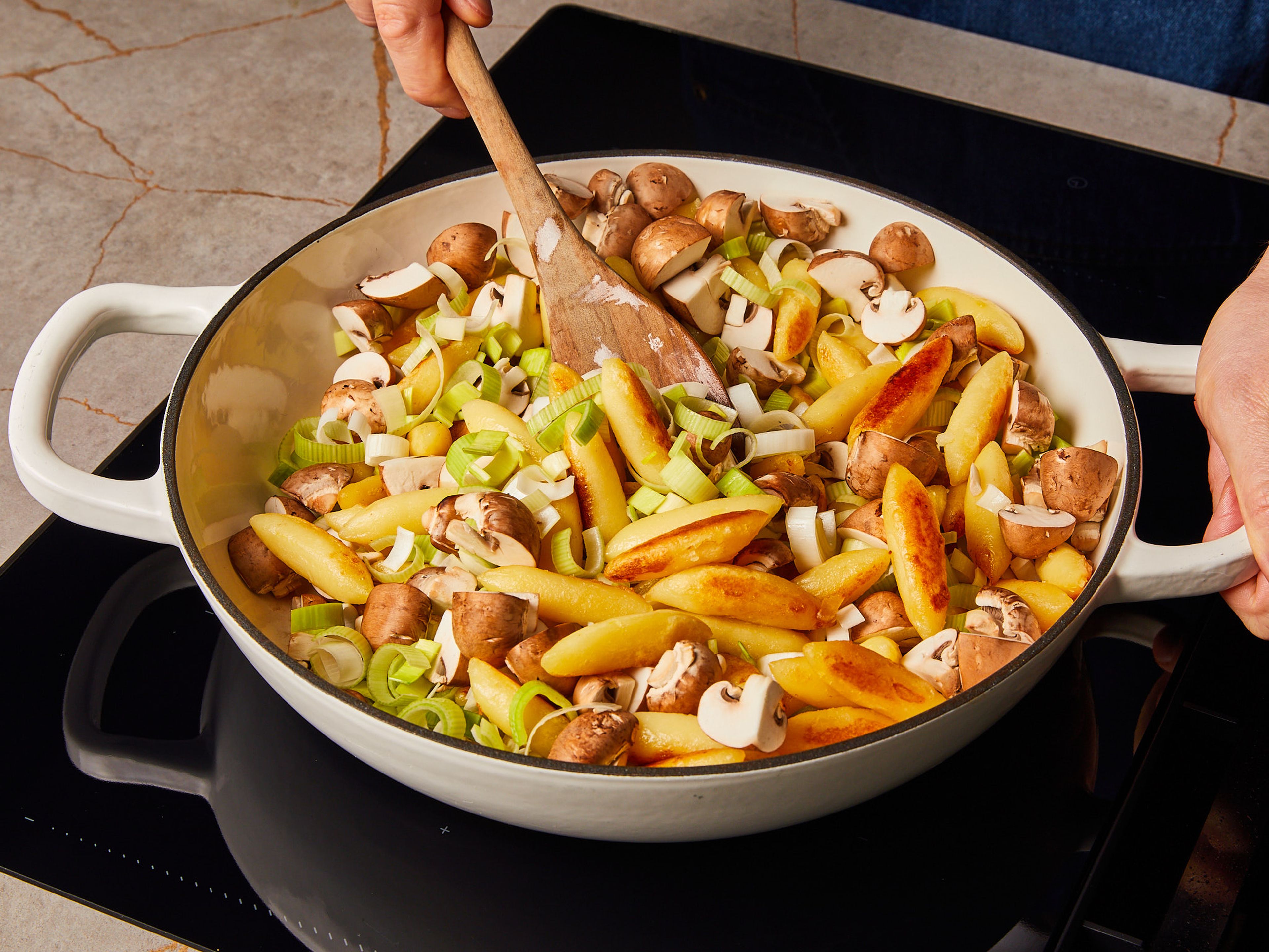 Heat oil in an ovenproof frying pan. Sauté the German gnocchi for approx. 3–4 min. until golden brown, then add garlic, leeks, and mushrooms. Reduce heat slightly and sauté everything together for approx. 4–6 min. until leeks have cooked down a bit.