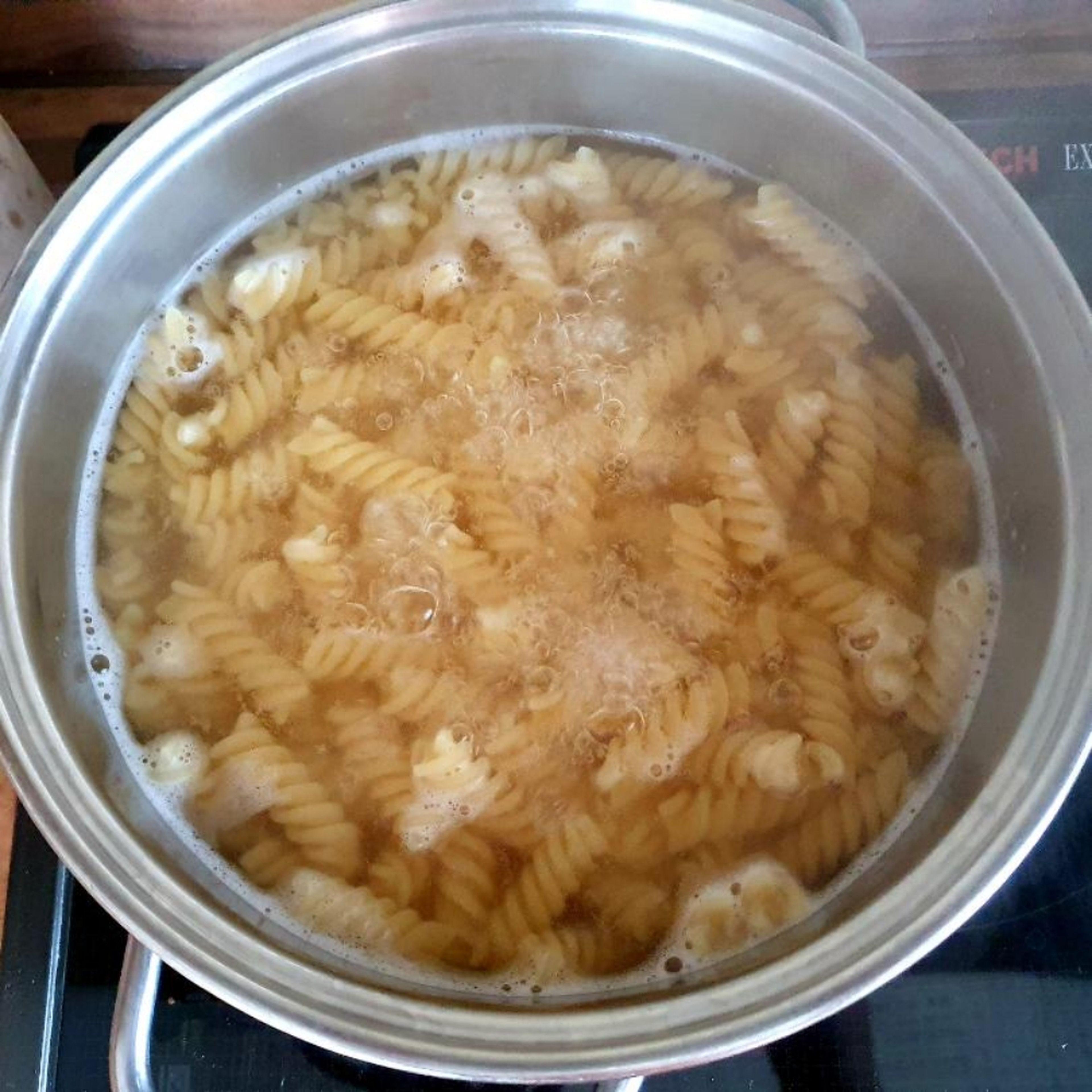 Die Nudeln im Salzwasser gar kochen.
