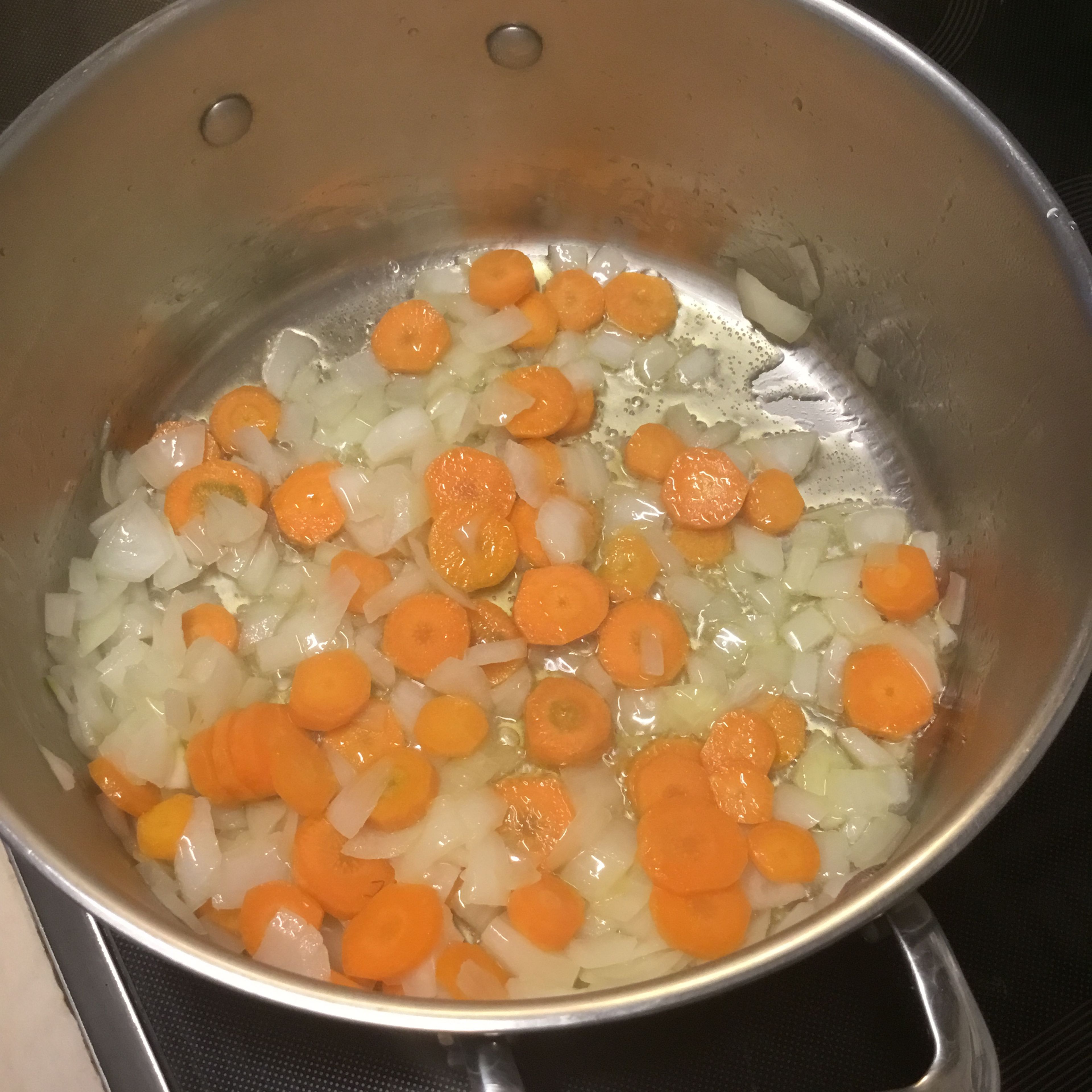 Karotten hinzufügen und ebenfalls 5-7 Minuten dünsten.