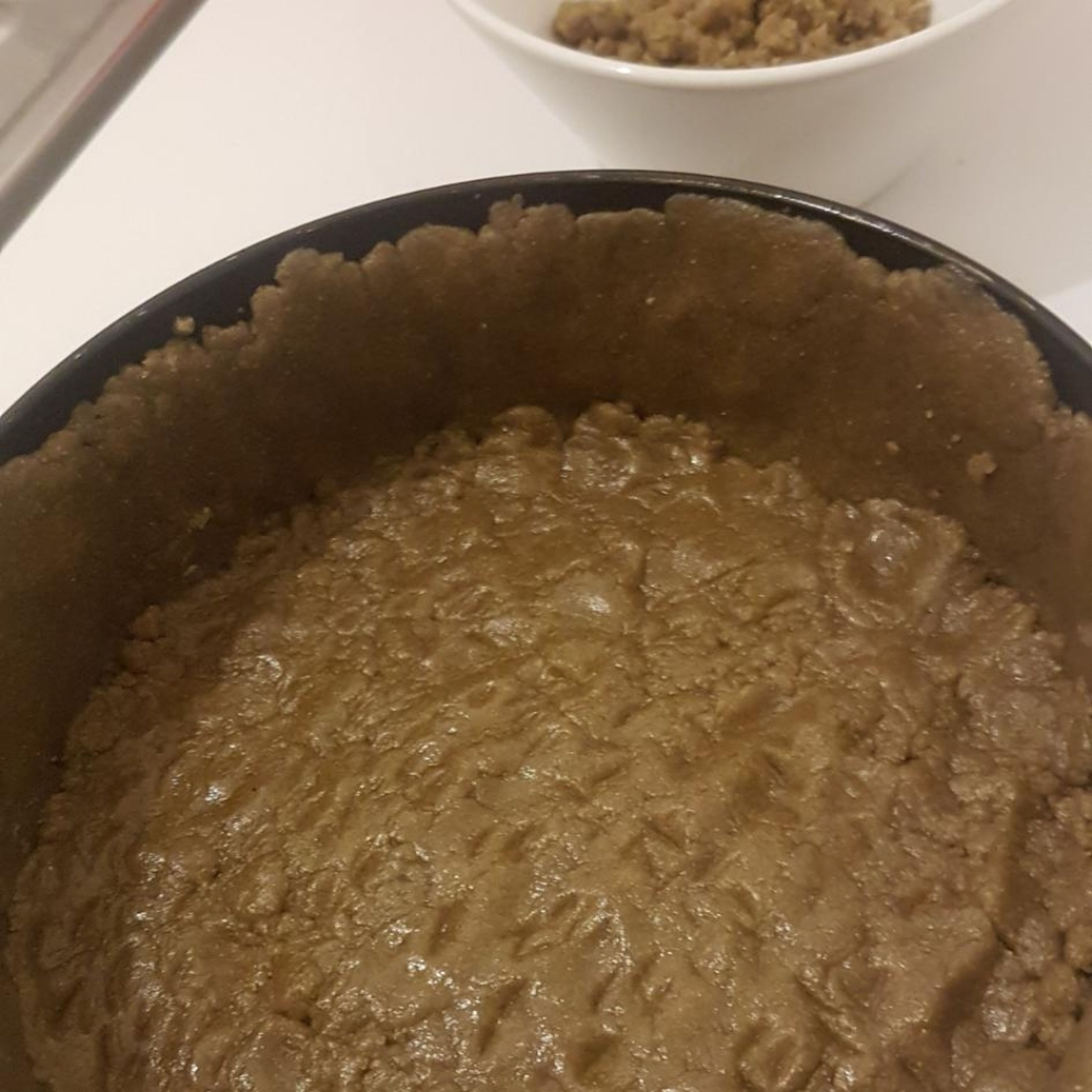 Mehl und Backpulver sieben. Die Zutaten in der Reihenfolge zu einem Mürbeteig verrühren und in einer 30cm Springform ausbreiten, bis auf 1cm unter dem Rand.