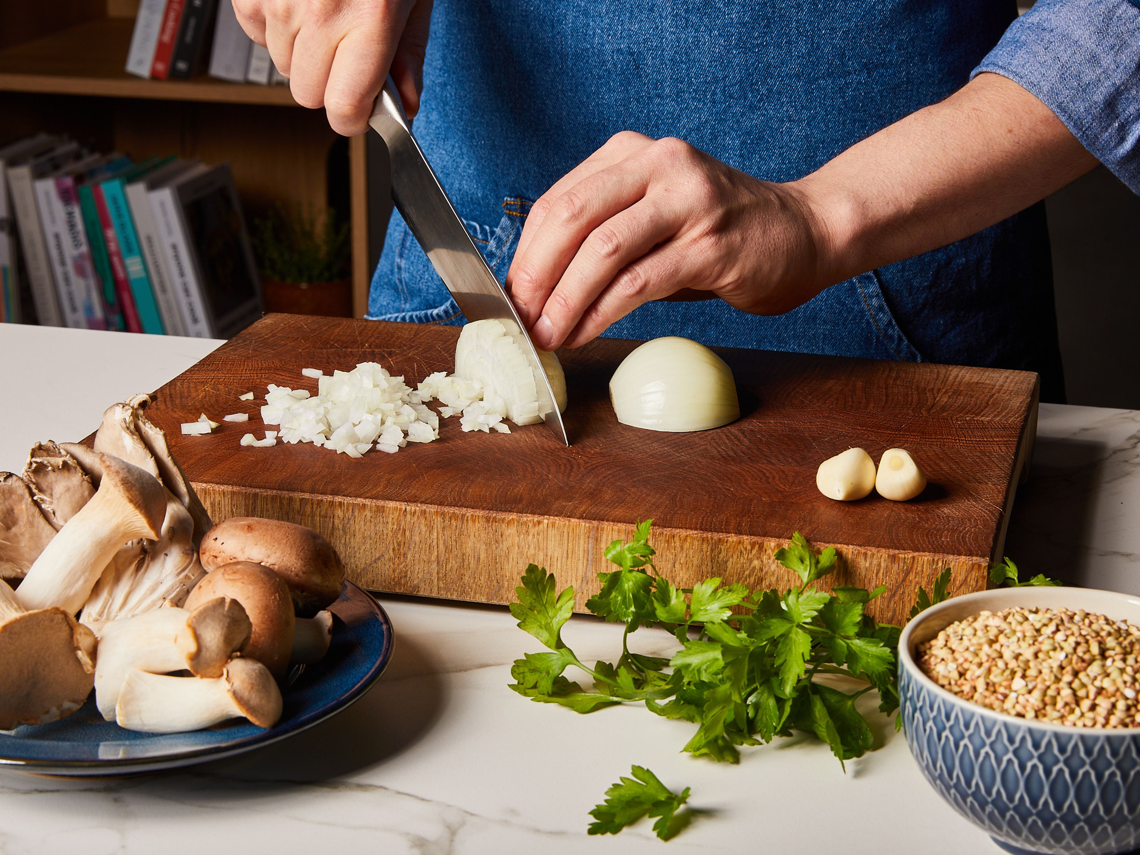 Die Zwiebel und die Knoblauchzehe schälen und fein hacken. In einem Topf die Hälfte des Olivenöls und die vegane Butter bei mittlerer Hitze erhitzen. Die gehackte Zwiebel und den Knoblauch hinzufügen und ca. 3–4 Min. anbraten, bis sie weich sind.