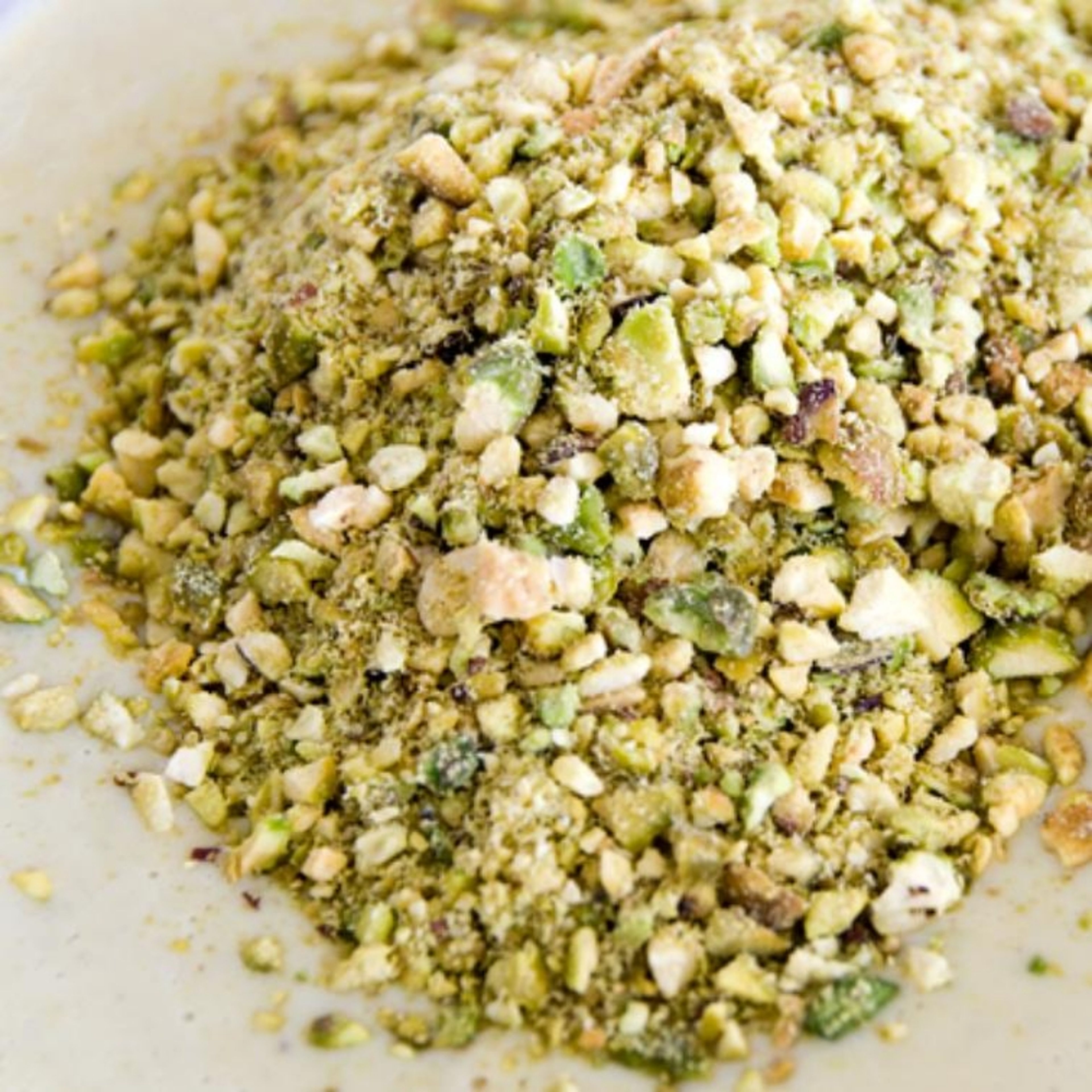 Chop the pistachios finely, or blitz in a food processor until in small chunks. Separate away 10 g of pistachios for garnish.
