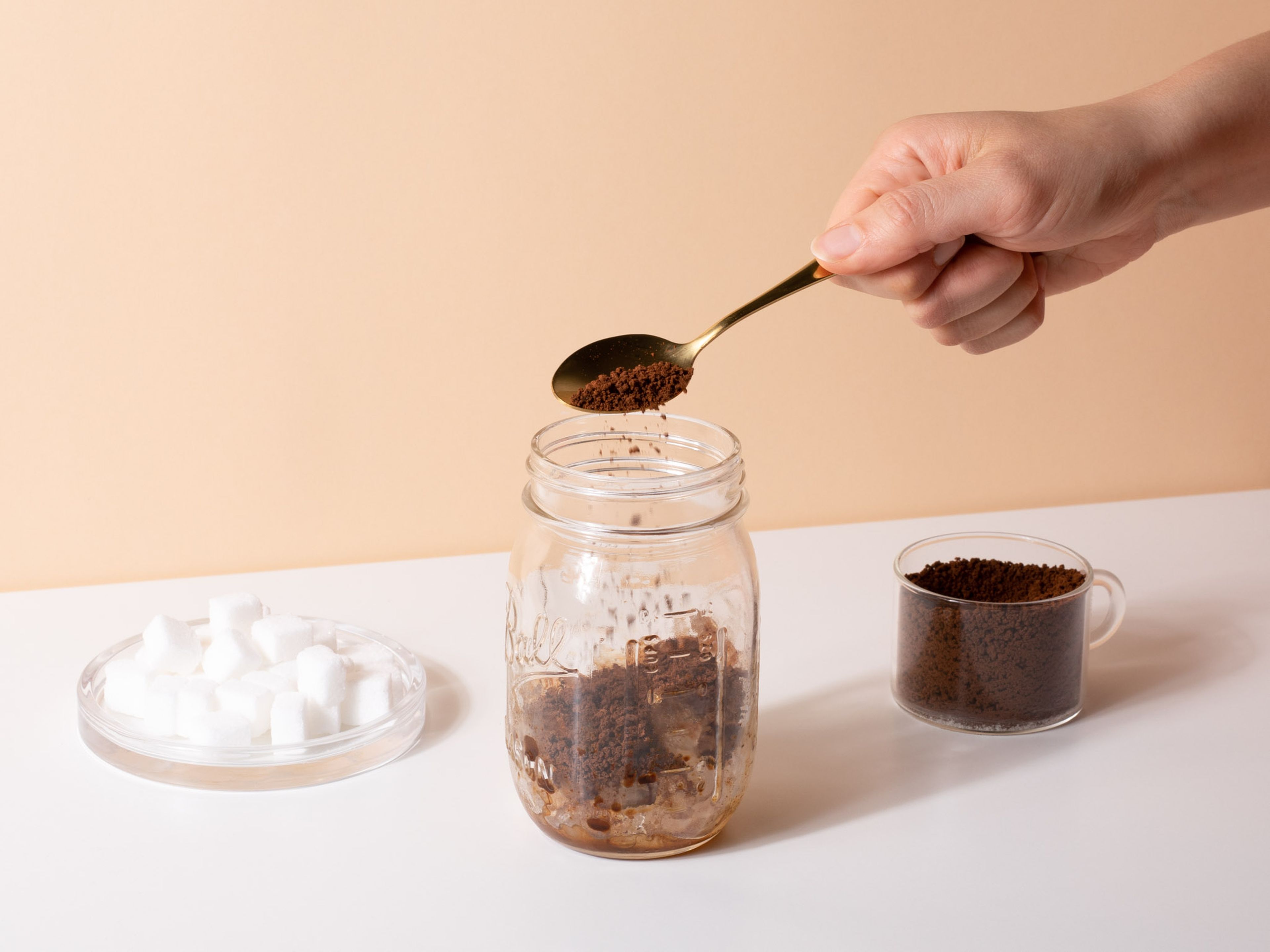 Eiswürfel, Kaffeepulver, Zucker und Wasser in ein Einmachglas geben.