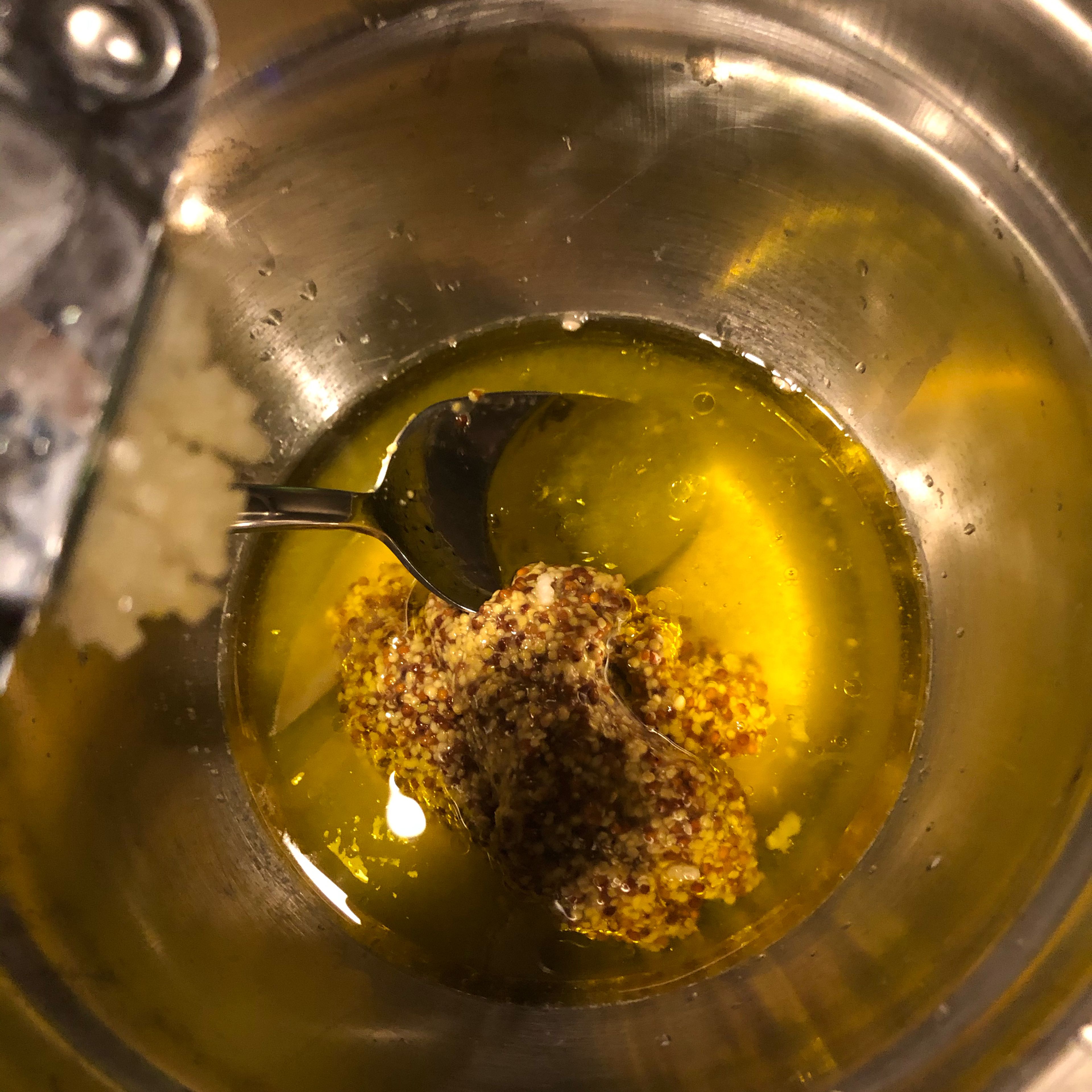 Das Dressing: In einer kleinen Schüssel Olivenöl, Zitronensaft, Senf, Honig vermengen. Knoblauch hineinpressen. Miteinander vermengen.