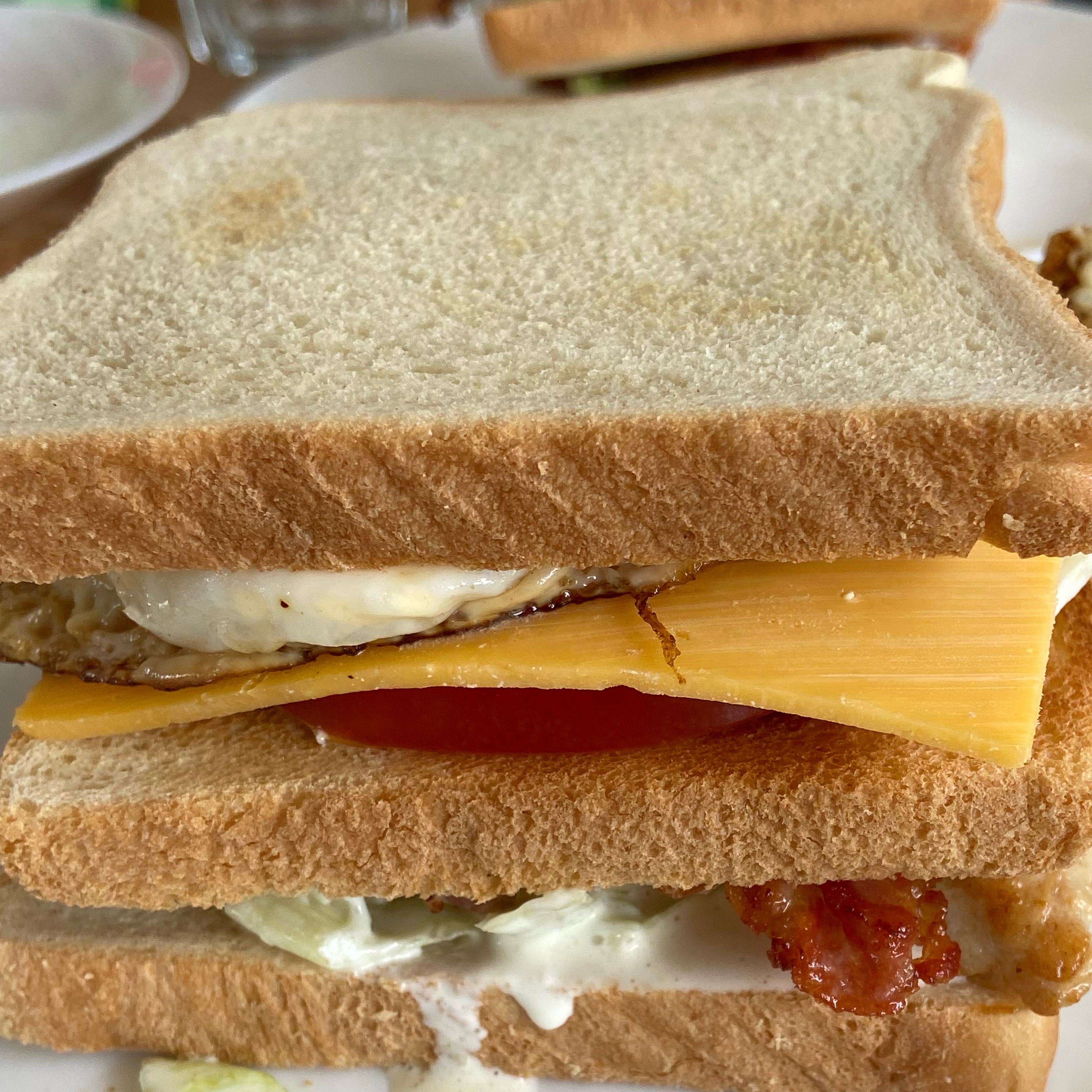 Take the hot fried egg and lay it on top of the cheddar cheese, which will allow it to melt a bit, and finally set the last slice of bread on top, squeeze gently, cut in the middle and enjoy!