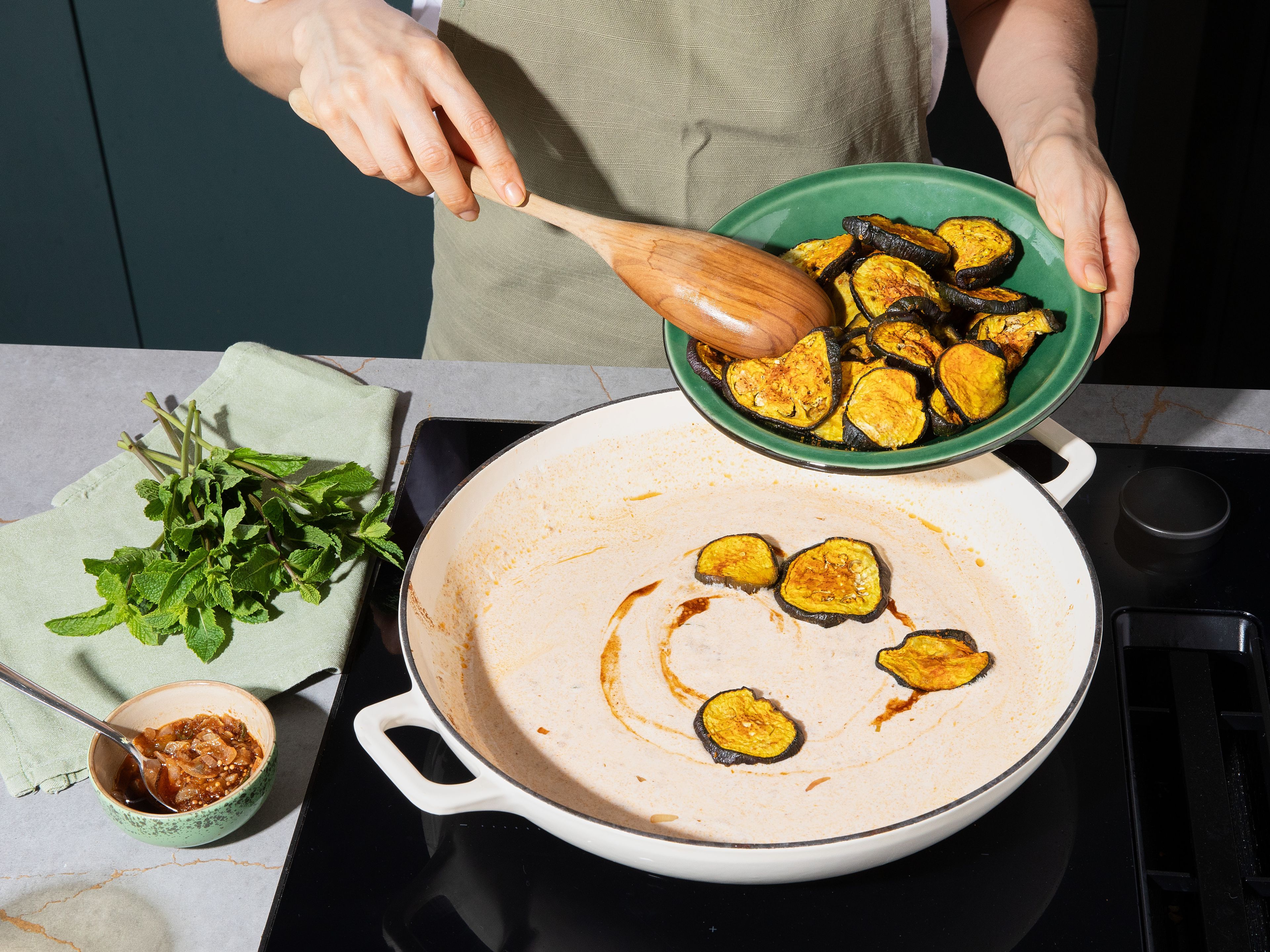 For the yogurt sauce, stir yogurt with cornstarch until smooth. Reduce pan heat and gradually add yogurt to Tadka while stirring constantly. Warm gently, avoiding boiling. If necessary, stir in some water until a creamy sauce forms. Season with salt. To serve, gently fold roasted eggplants into the yogurt sauce. Garnish with remaining Tadka and fresh mint. Serve with basmati rice or naan bread.