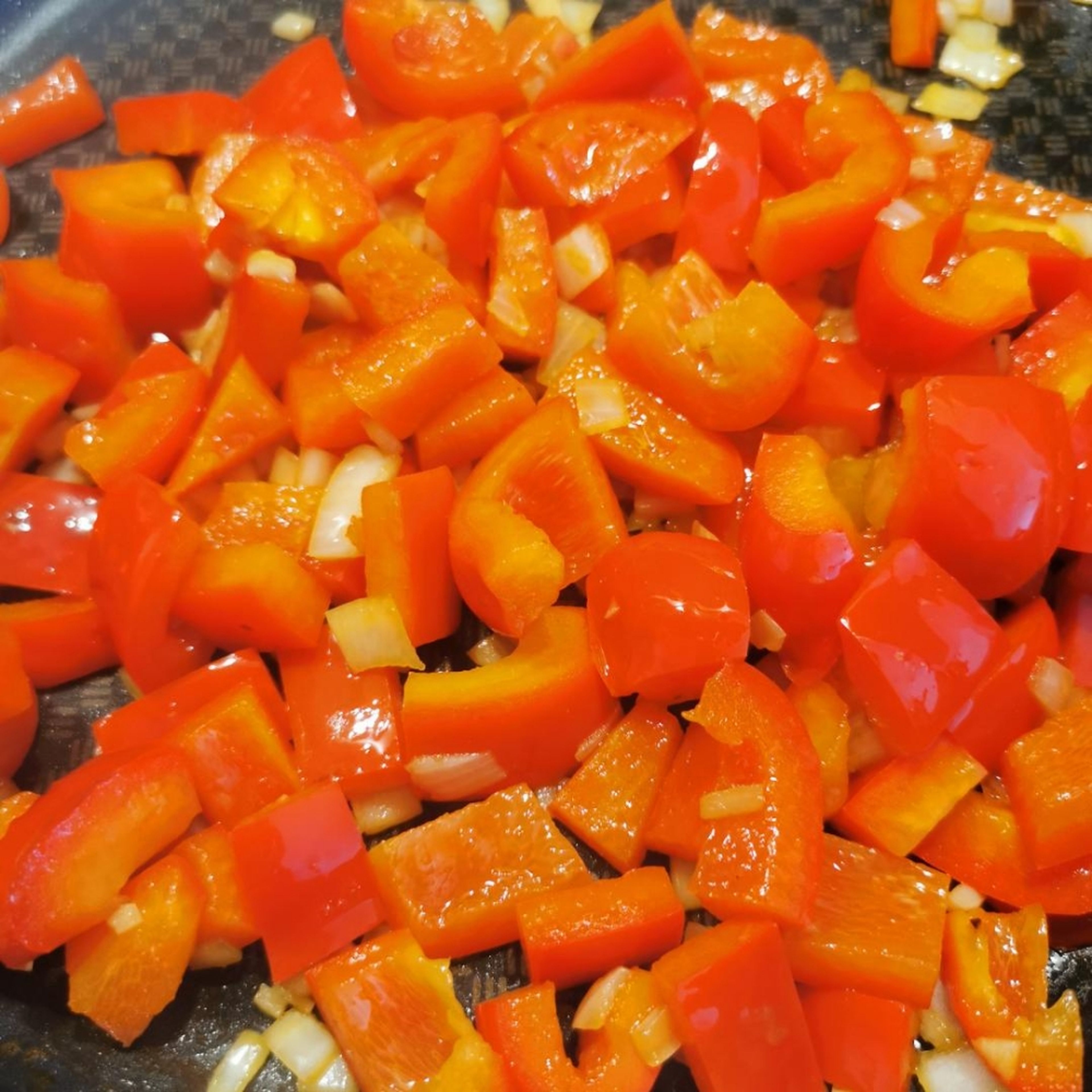 Paprika, Knoblauch und Zwiebel in Öl anbraten bei mittlerer Hitze bis die Zwiebeln glasig sind.