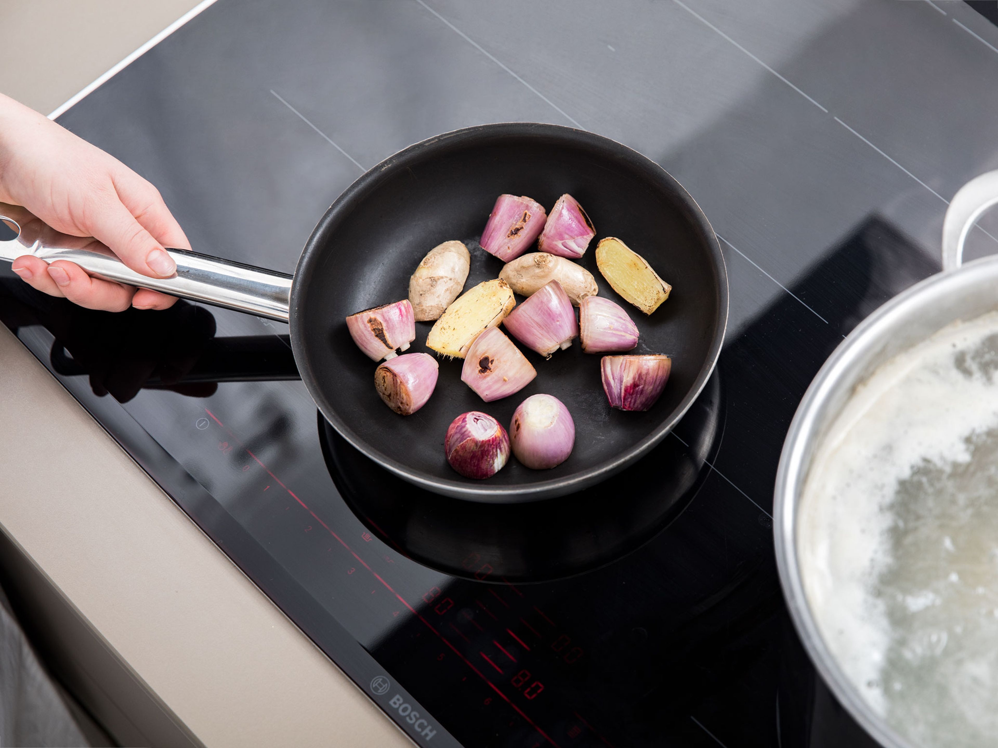 Peel shallots and add to a frying pan with ginger. Fry until they start to turn very dark brown, then add to the pot. Let the broth simmer over medium-low heat for approx. 2 hrs. Discard beef bone, oxtail, ginger and shallots. Remove boiled beef and transfer to a bowl with cold water.