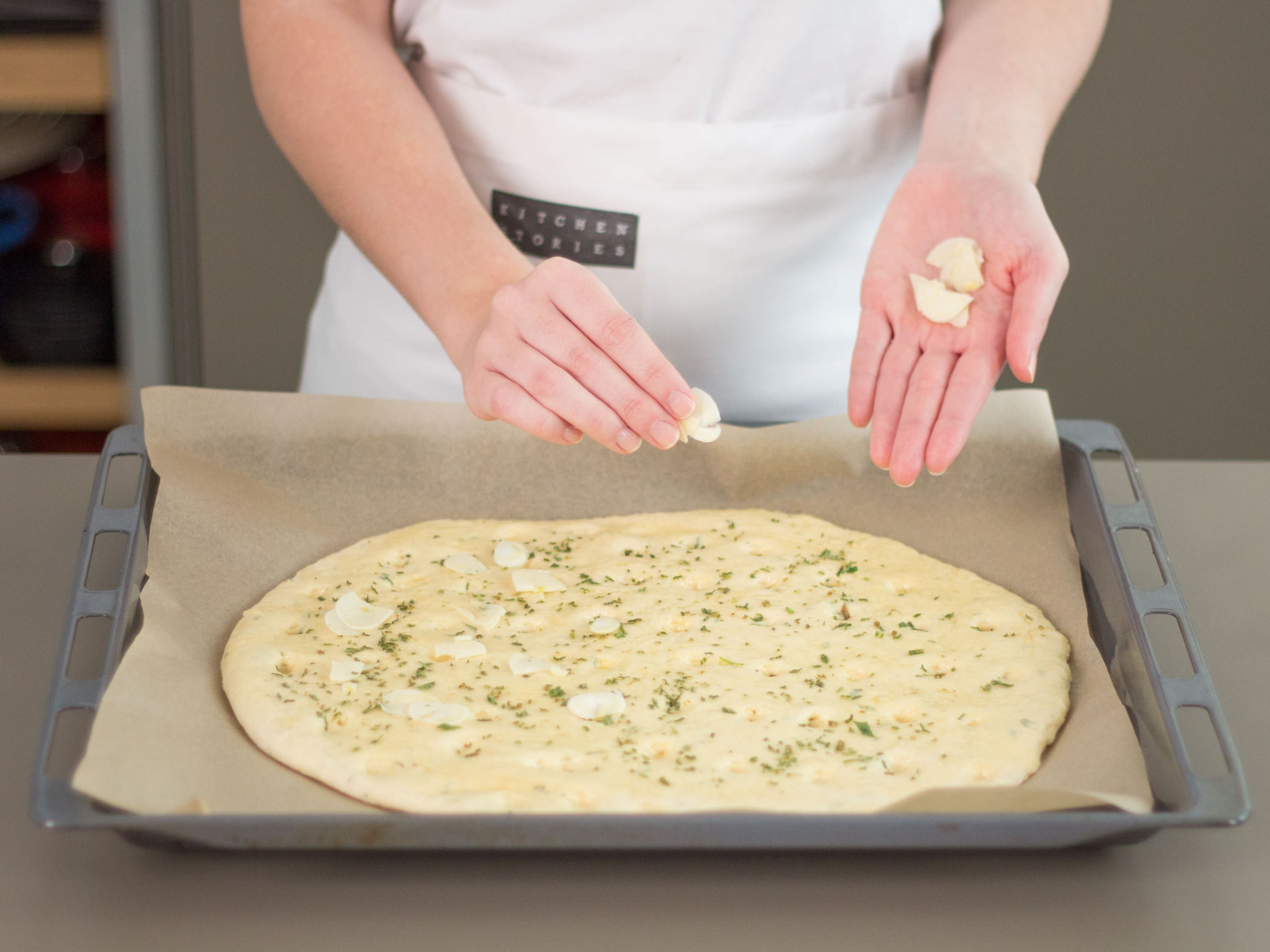 Flatten out dough until it is approx. the thickness of your thumb. Transfer to a parchment-lined baking sheet. Lightly press holes into the surface of dough with index finger. Cover dough again, then, preheat oven to 200°C/400°F. Before placing dough in oven, once again lightly press holes into its surface with index finger. Brush with olive oil and garnish with rest of garlic and rosemary. Bake in preheated oven at 200°C/400°F. for approx. 20 – 25 min. Remove from oven and sprinkle with sea salt. Enjoy!