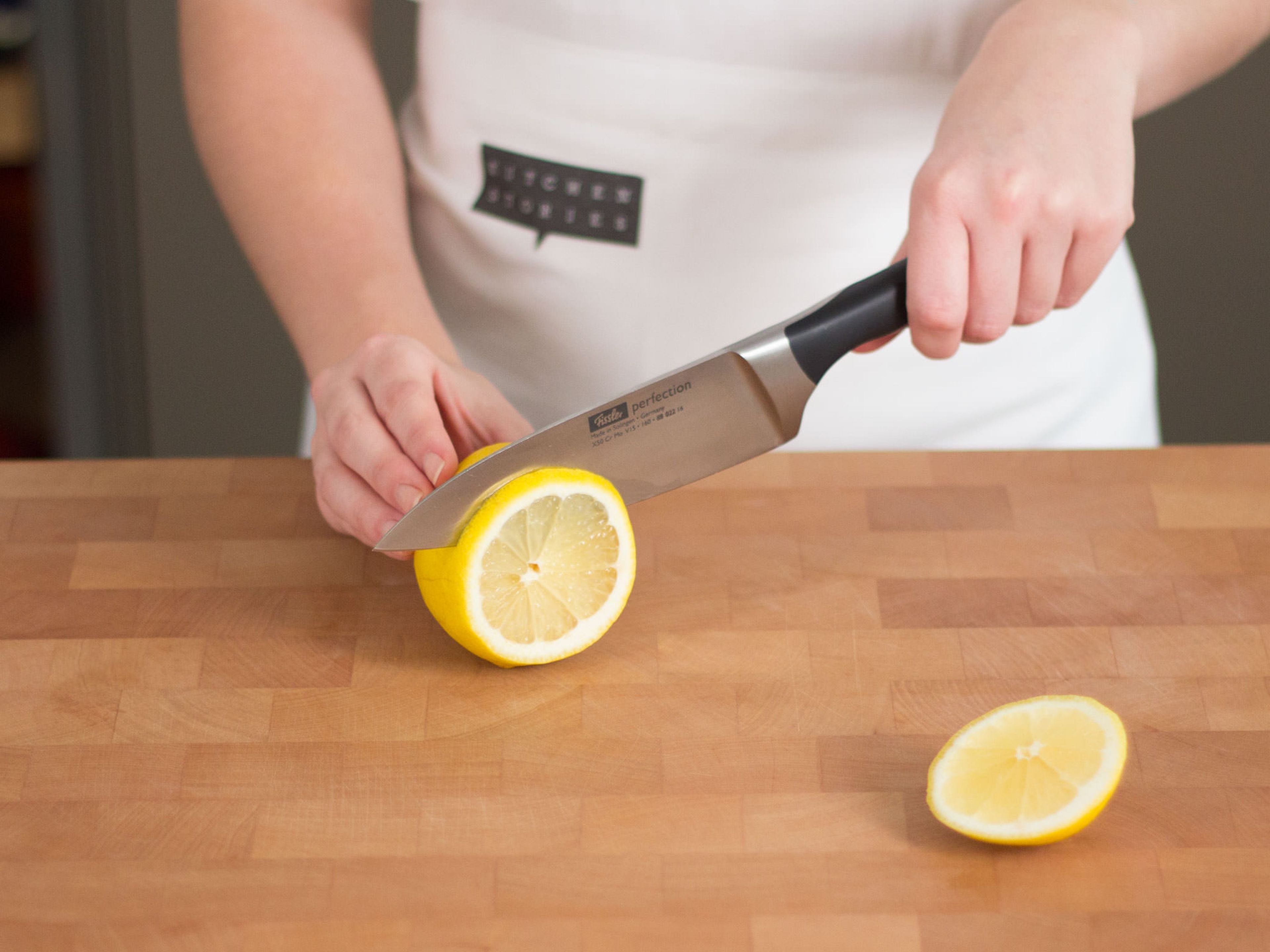 Zitrone in dünne Scheiben schneiden.