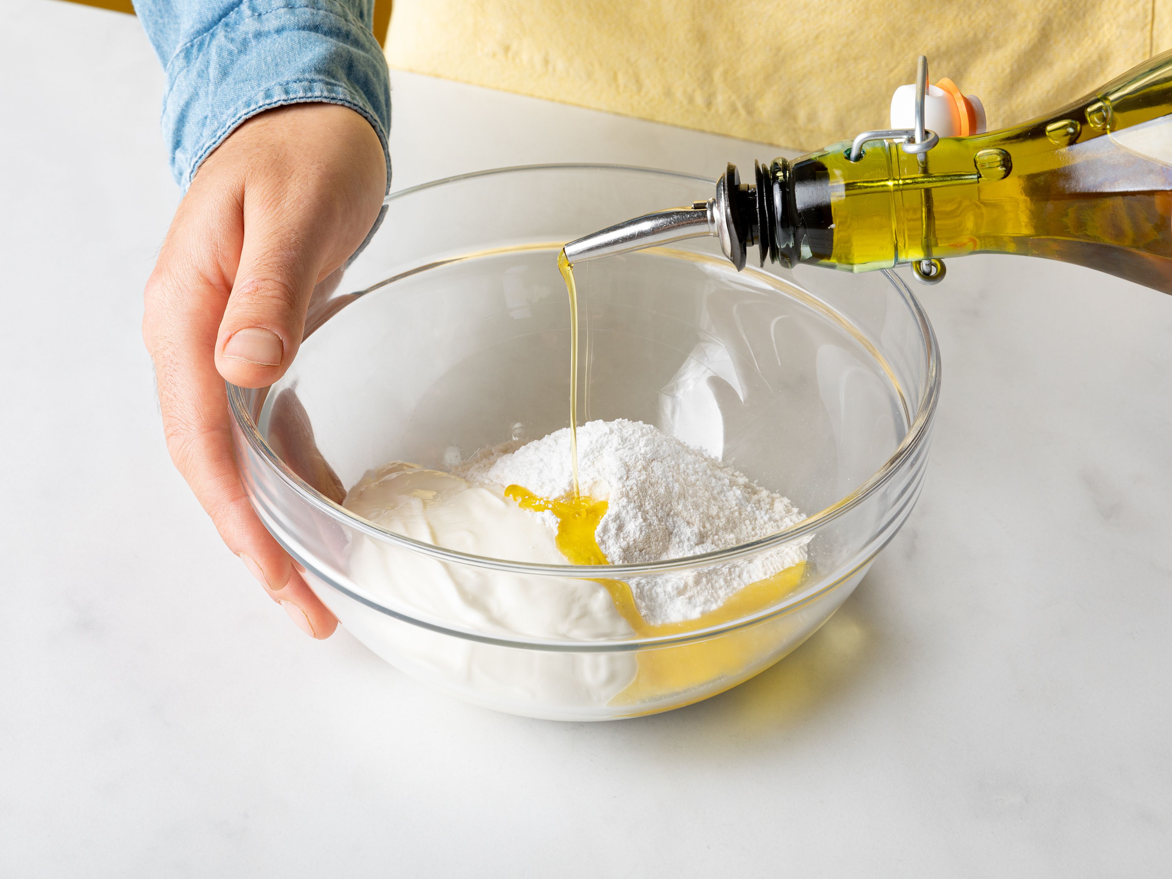 Griechischen Joghurt, Mehl, Backpulver, Olivenöl und Salz in eine große Schüssel geben und zu einem Teig formen. Den Teig anschließend auf einer leicht geölten Oberfläche ausrollen und zu einem Fladenbrot formen.