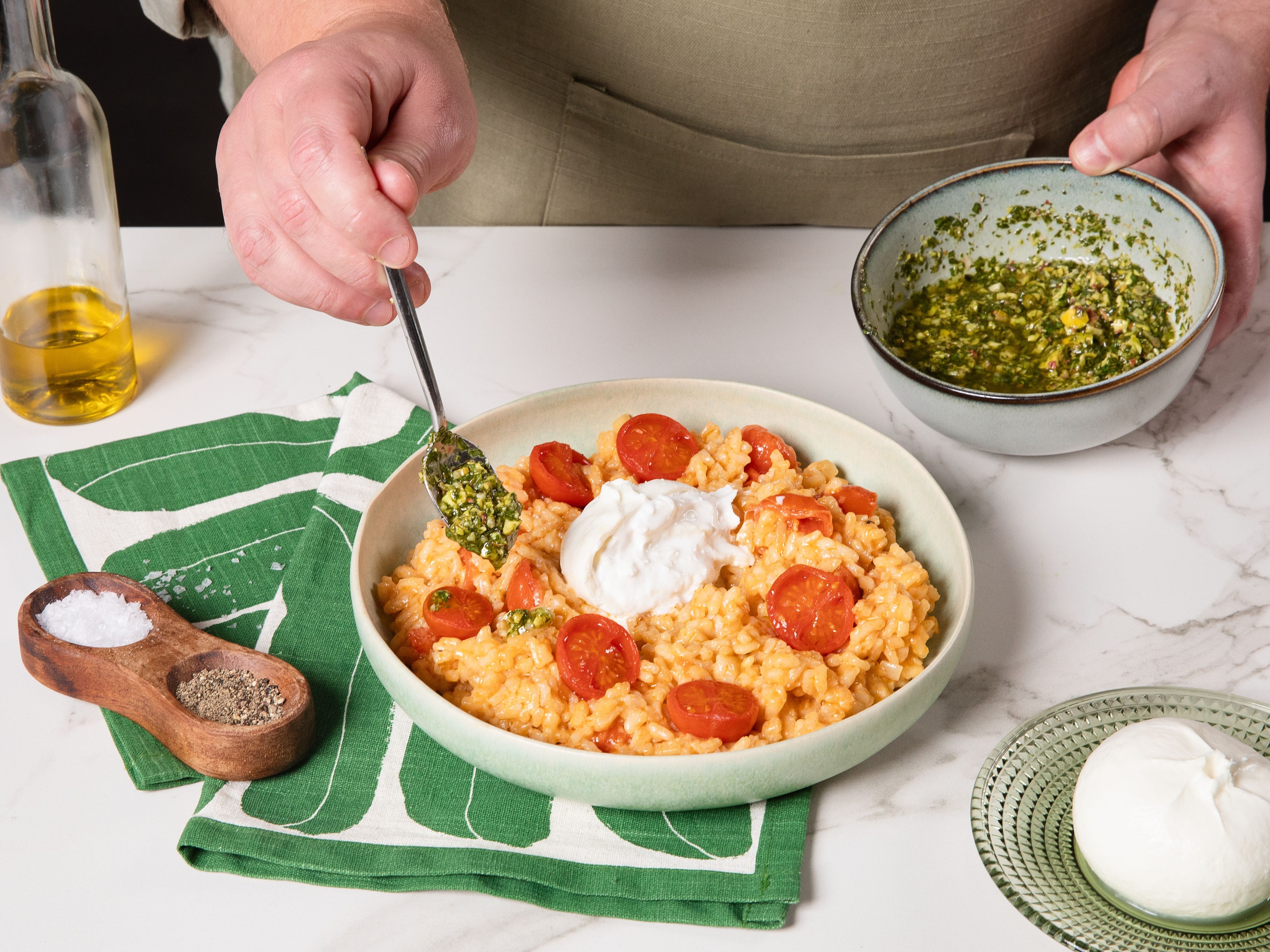 Das fertige Risotto auf Tellern verteilen, jeweils einen halben Burrata daraufgeben und grob aufreißen. Zum Schluss mit der Gremolata toppen und etwas Rucola und frischen schwarzen Pfeffer darüber geben.