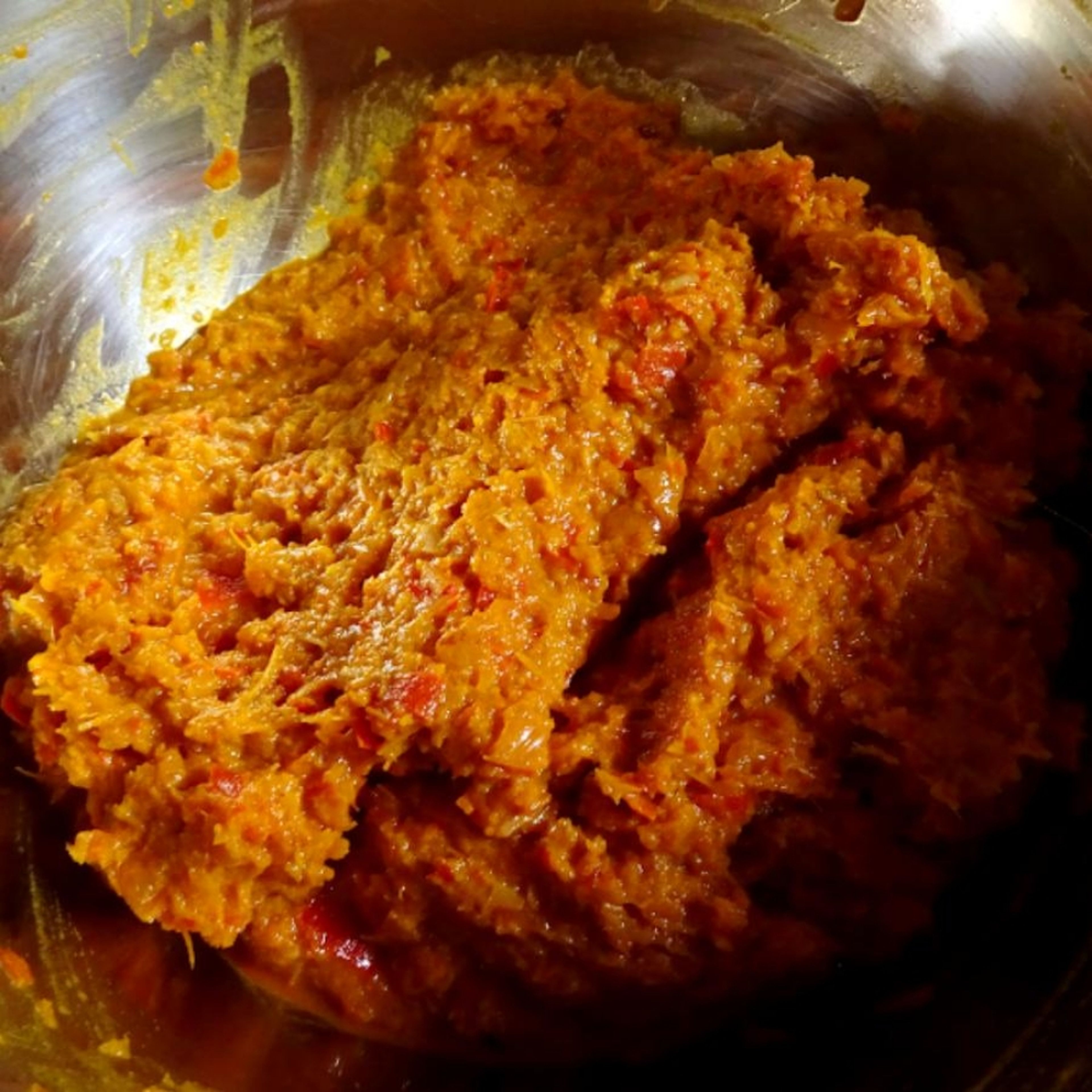 Prepare the curry paste by chopping 2 stalks of lemongrass, chillies, dried chillies, shallots, garlic, and gallangal before putting it into the pestle and mortar to pound until a smooth paste is formed. Combine the tumeric powder at the end and add in some salt to taste.