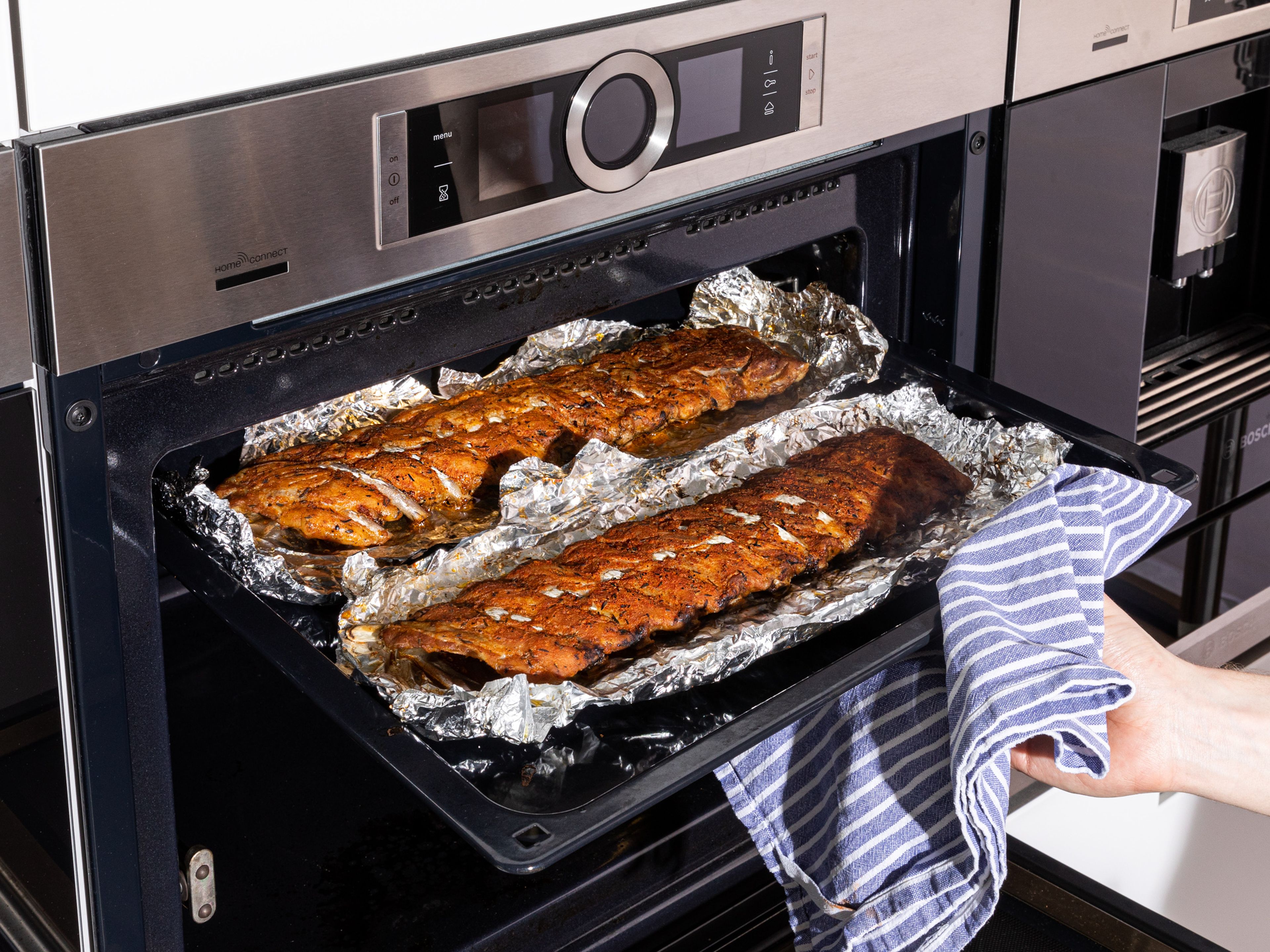 After 2 ½ hrs., remove the ribs from the oven and allow to rest for 15 min. In the meantime, heat the oven up to 220°C /430°F top/bottom heat. After the resting time, open the ribs package and pour out the excess liquid into a bowl. Then turn the ribs over, so that the meaty side is facing up. Remove any excess foil, and then return the ribs to the oven with the baking sheet on the highest shelf (as near to the heating element as possible) and bake for approx. 5 min., so a crust forms on the meat.