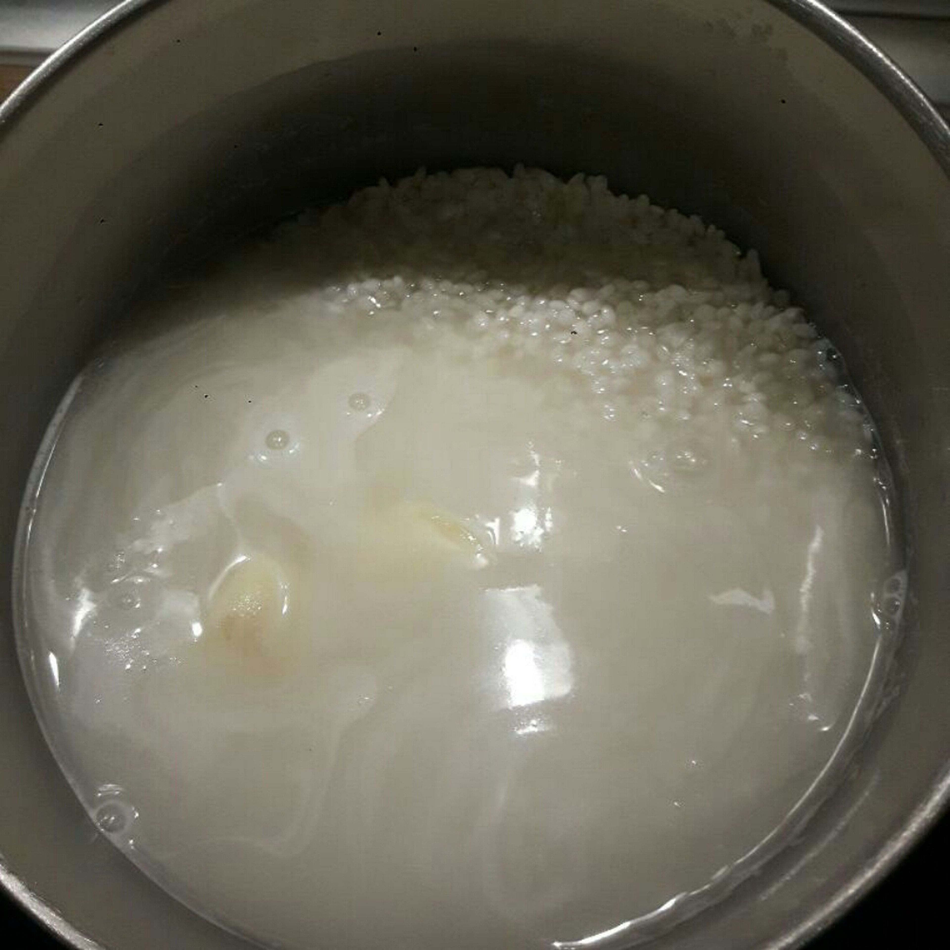 Reis mit 2 ganzen Knoblauchzehen, Salz und Wasser zum Kochen bringen und gemäß Packungsanleitung garen.
