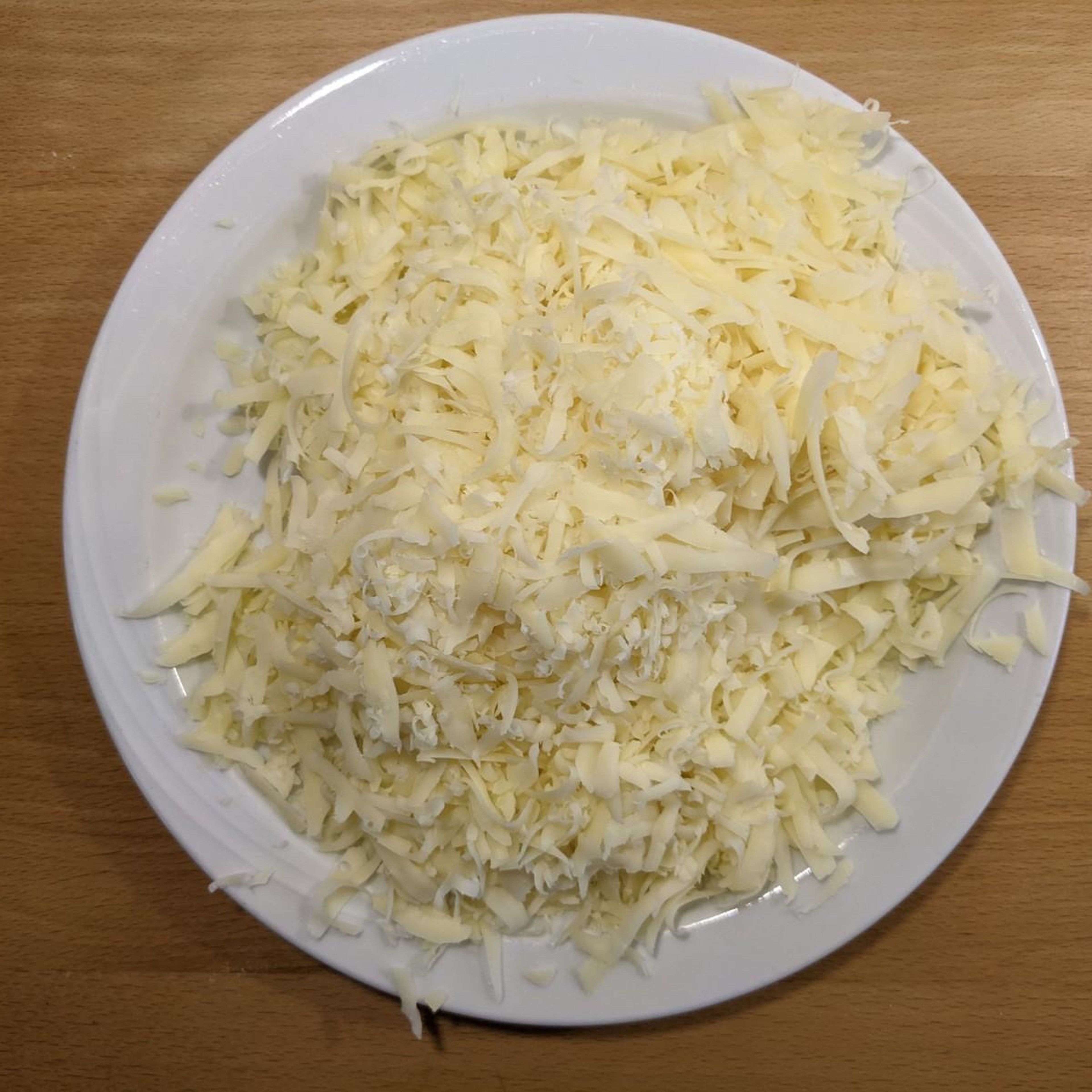 Hole dir eine Käsereibe und nutze die Seite, bei welcher die größte Käsestückchen übrigbleiben.