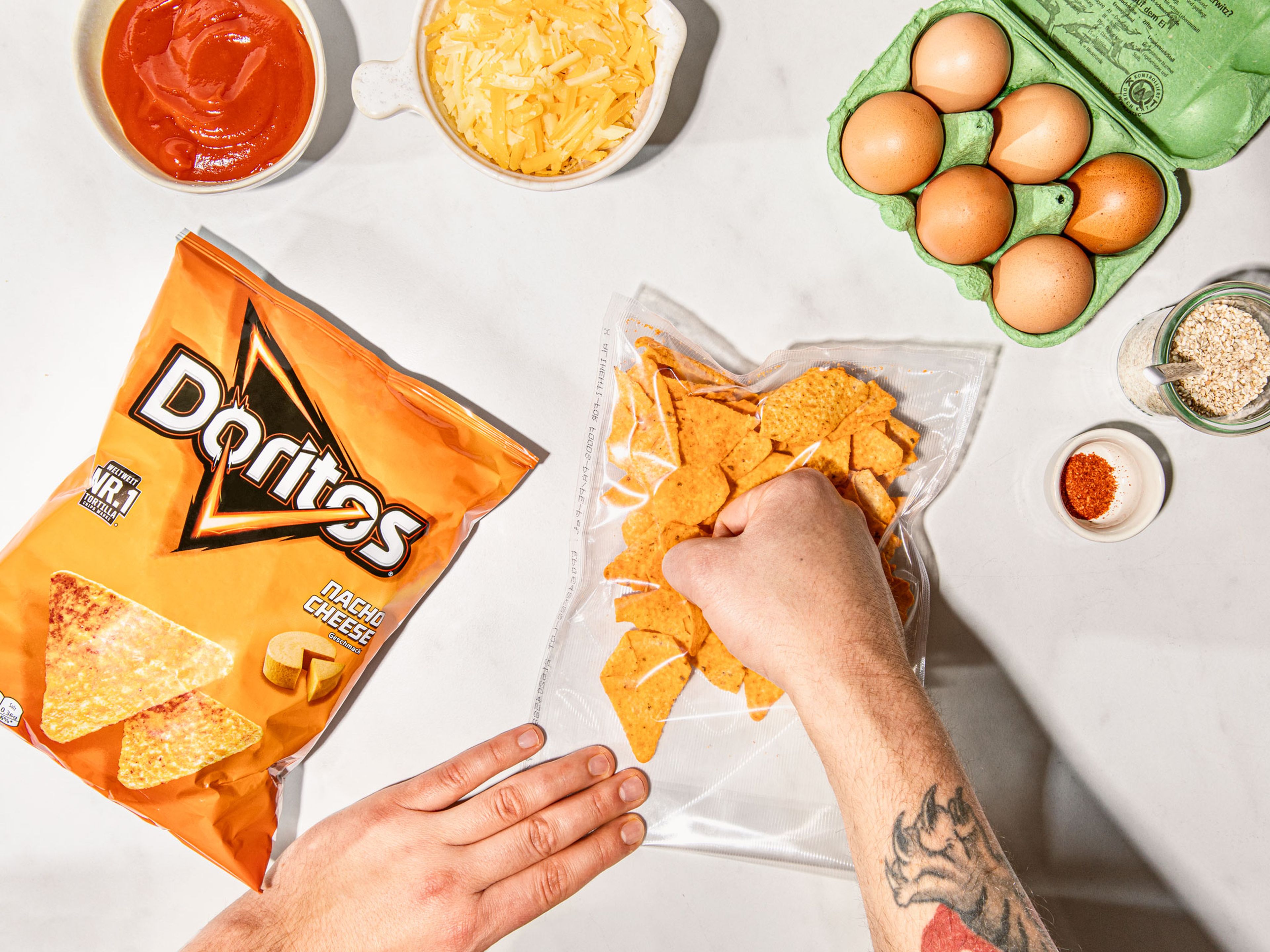 Preheat oven to 200°C/400°F. Transfer Doritos to a resealable freezer bag and crush until fine, then mix with cheddar cheese in a small bowl. Crack egg into another small bowl and beat. Line a baking sheet with parchment paper and set aside.