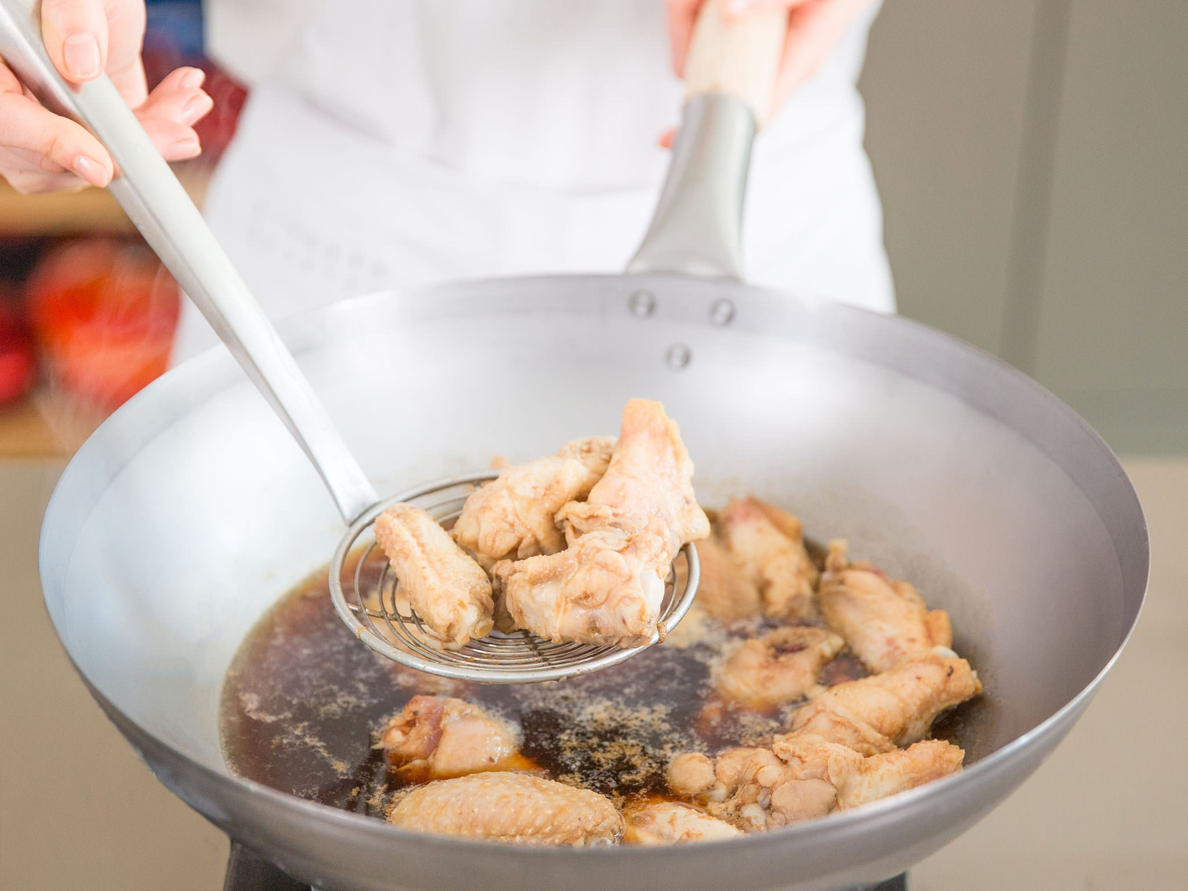 Fill wok a third of the way full with water and bring to a boil. Add chicken wings, blanch for approx. 3 – 5 min., and then remove from wok. Discard water.