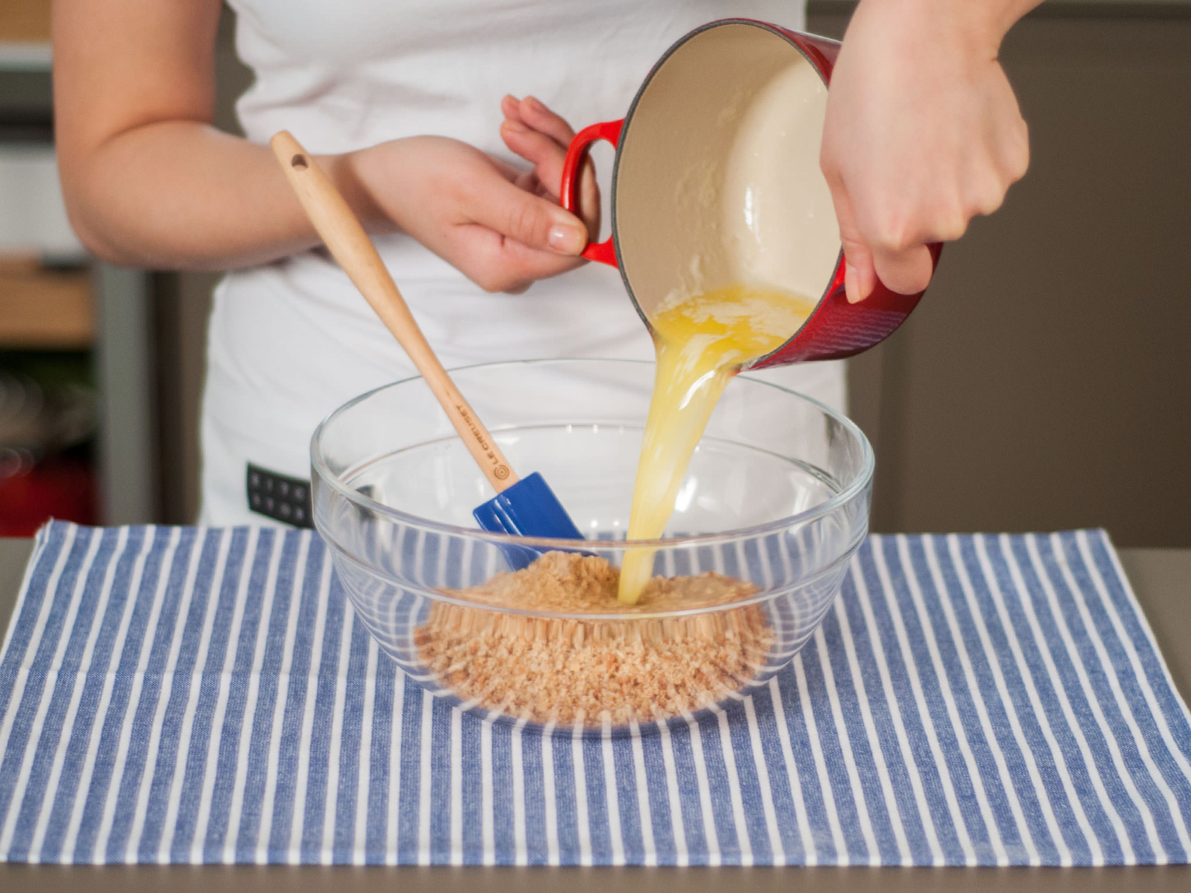 Butter in einem kleinen Topf bei mittlerer bis niedriger Hitze schmelzen. Kekskrümel in eine große Schüssel geben, geschmolzene Butter hinzugeben und sorgfältig vermengen.