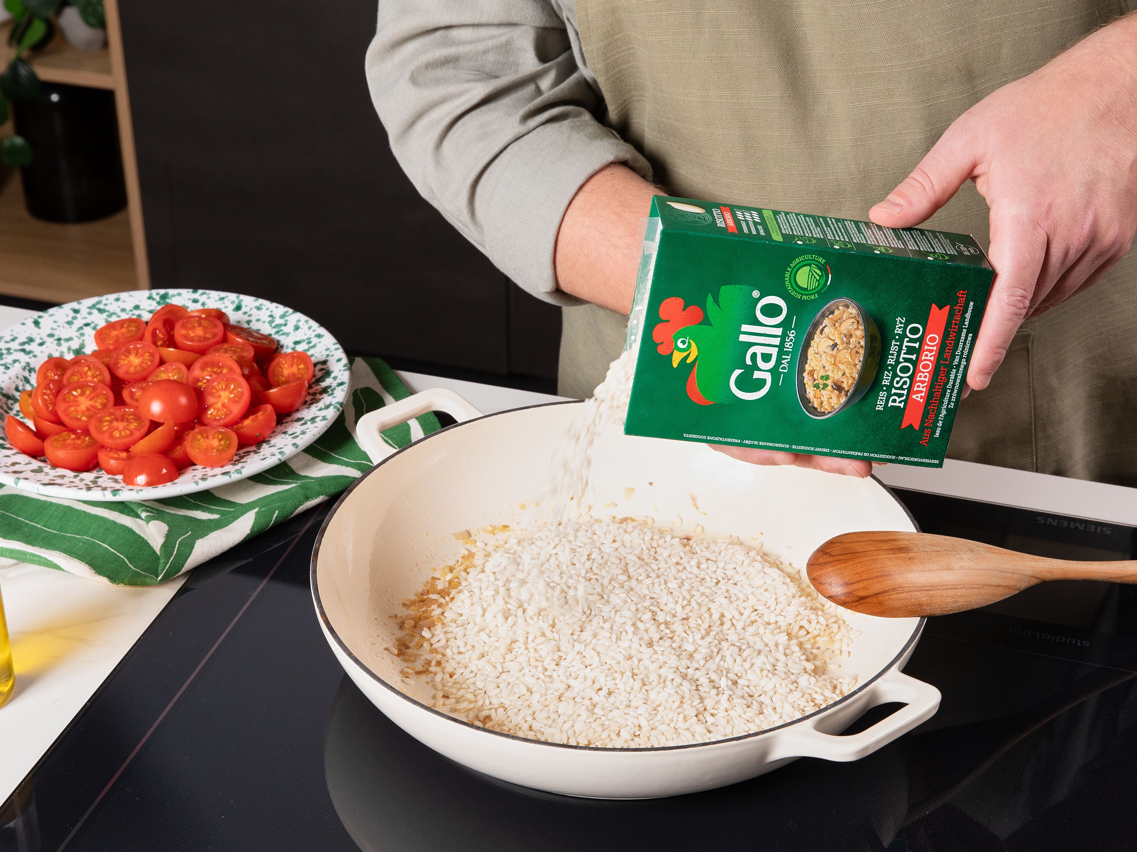 Die Schalotte schälen und fein hacken und die Tomaten halbieren. In einer großen Pfanne Olivenöl und die Hälfte der Butter erhitzen, bis die Butter geschmolzen ist. Schalotten hinzufügen und ca. 3 Min. bei mittlerer Hitze glasig  werden lassen. Dann den Knoblauch  hinzufügen und ca. 1 Min. mitbraten. Die Hitze erhöhen, den Riso Gallo Risotto Reis hinzufügen und ebenfalls mitbraten, bis er außen glasig wird und innen weiß ist.