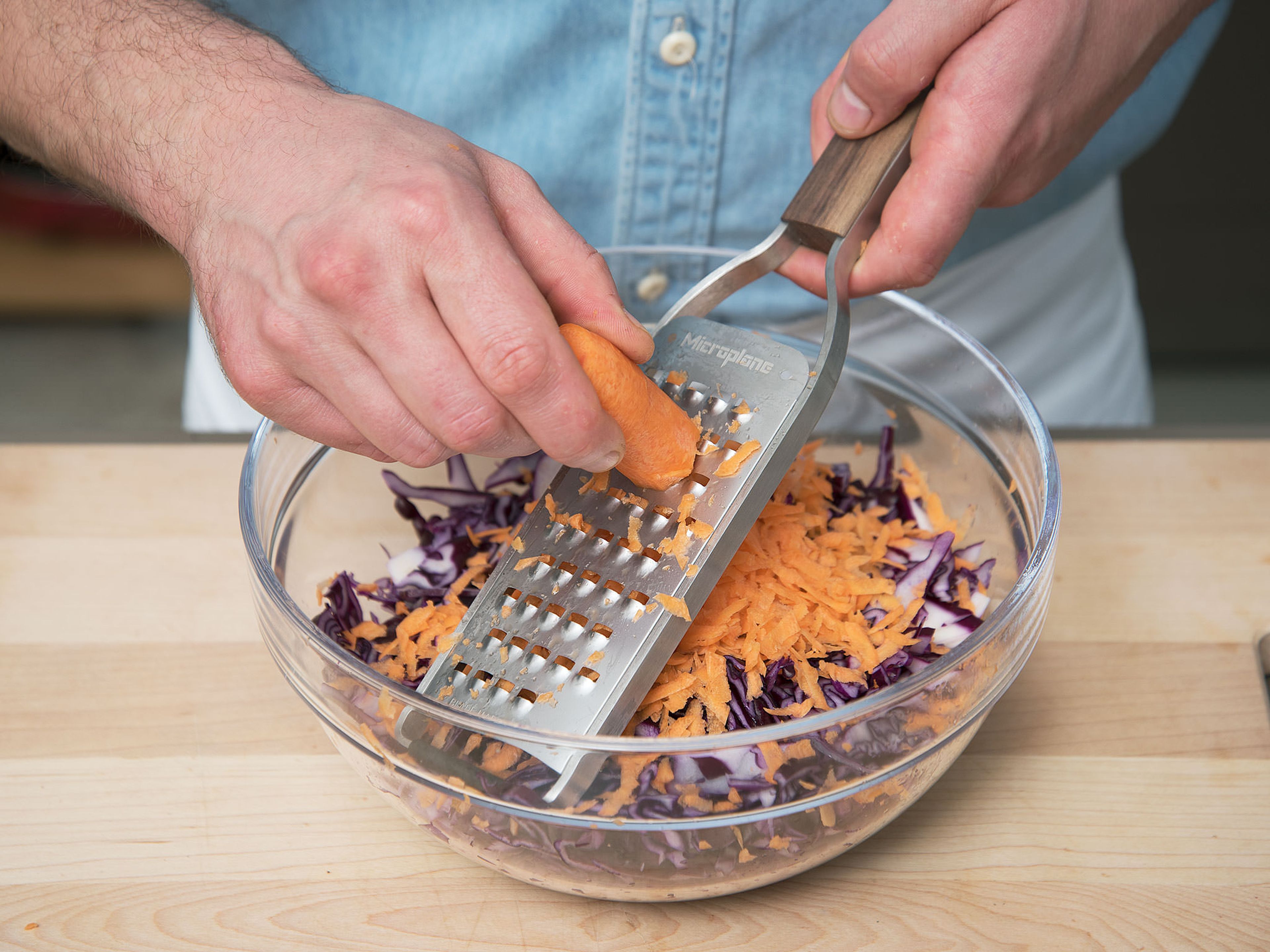 Remove stem and outer leaves from the red cabbage. Roughly cut and grate it into a large bowl. Wash and grate carrots, then add them to the red cabbage.