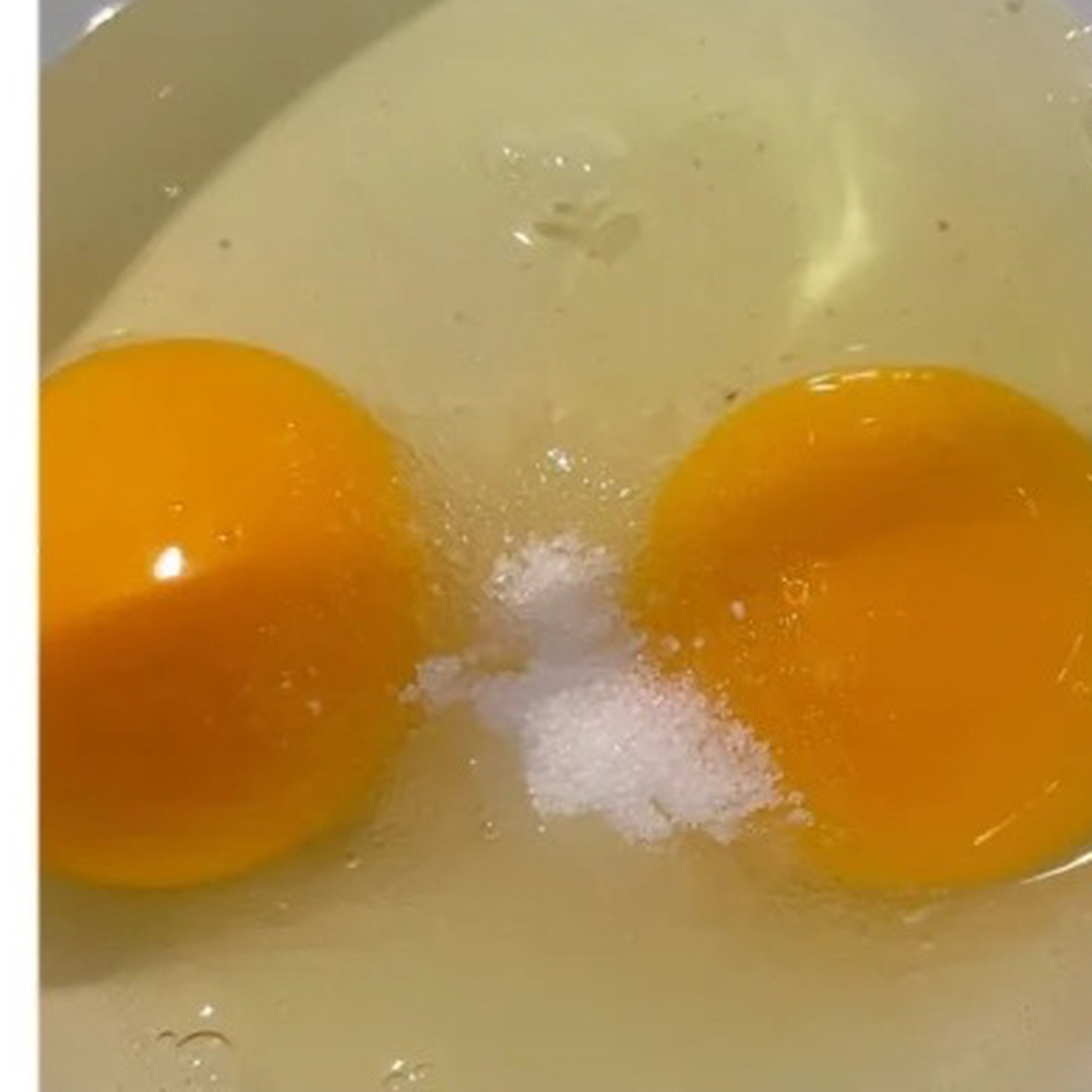Put 2 eggs into a big bowl. Then add sugar and oil in it.