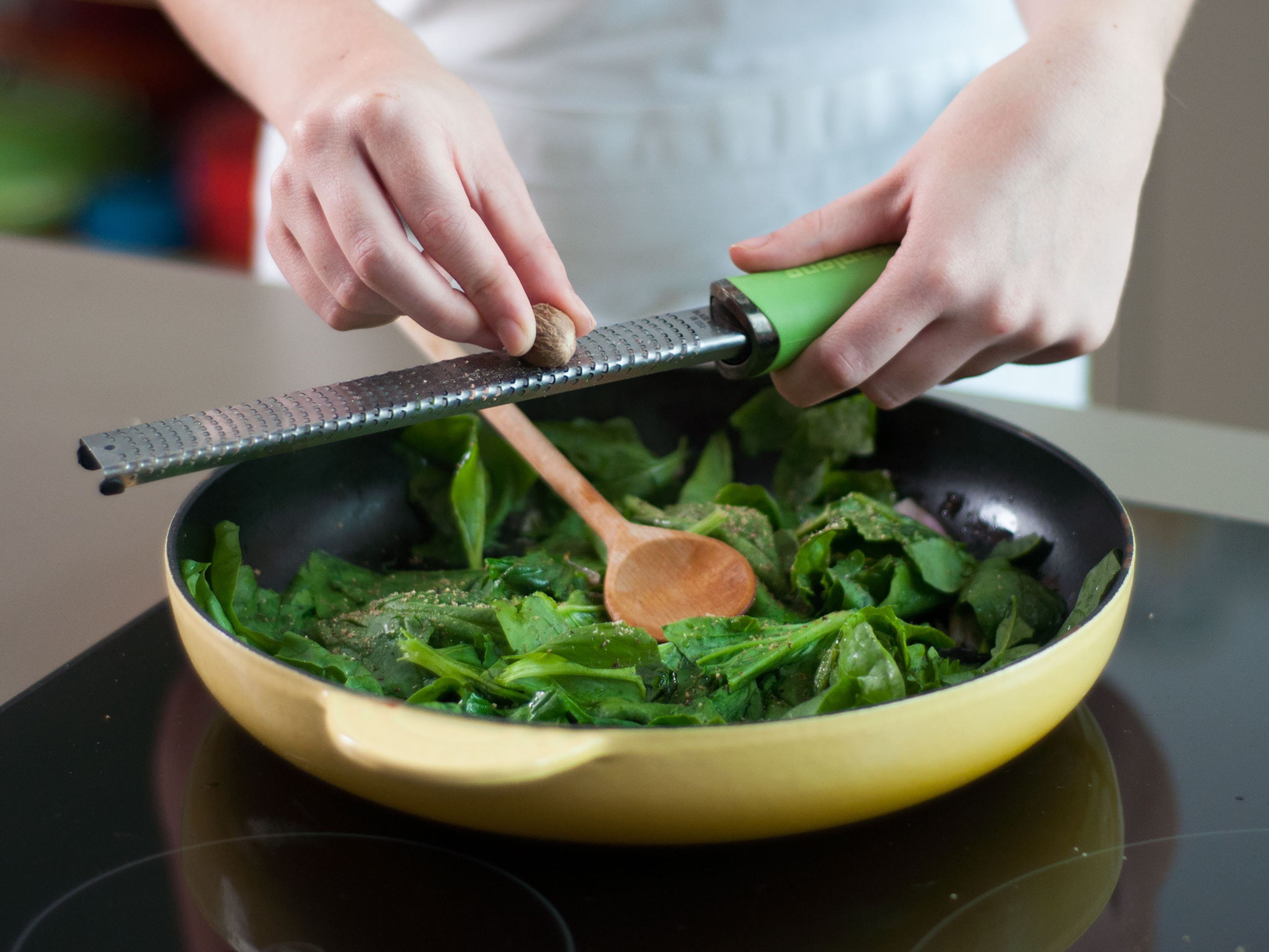 In a large frying pan, heat up some vegetable oil over medium heat and sauté shallot for approx. 1 – 2 min. Then, add spinach and continue to cook for approx. 1 – 2 min. until wilted. Grate nutmeg into pan and stir thoroughly. Remove from heat.